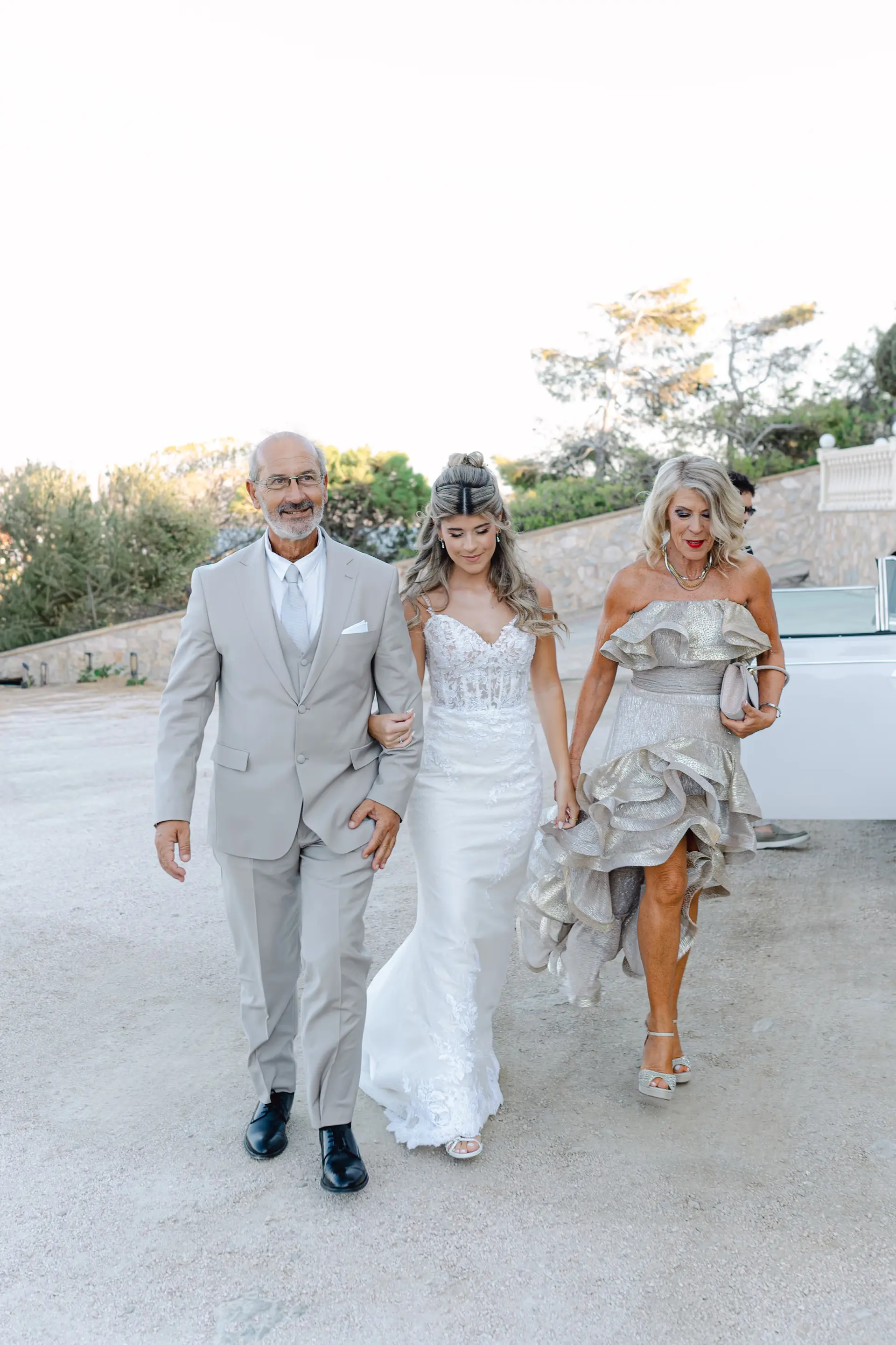 Bride walking with her family towards the wedding ceremony, full of emotion