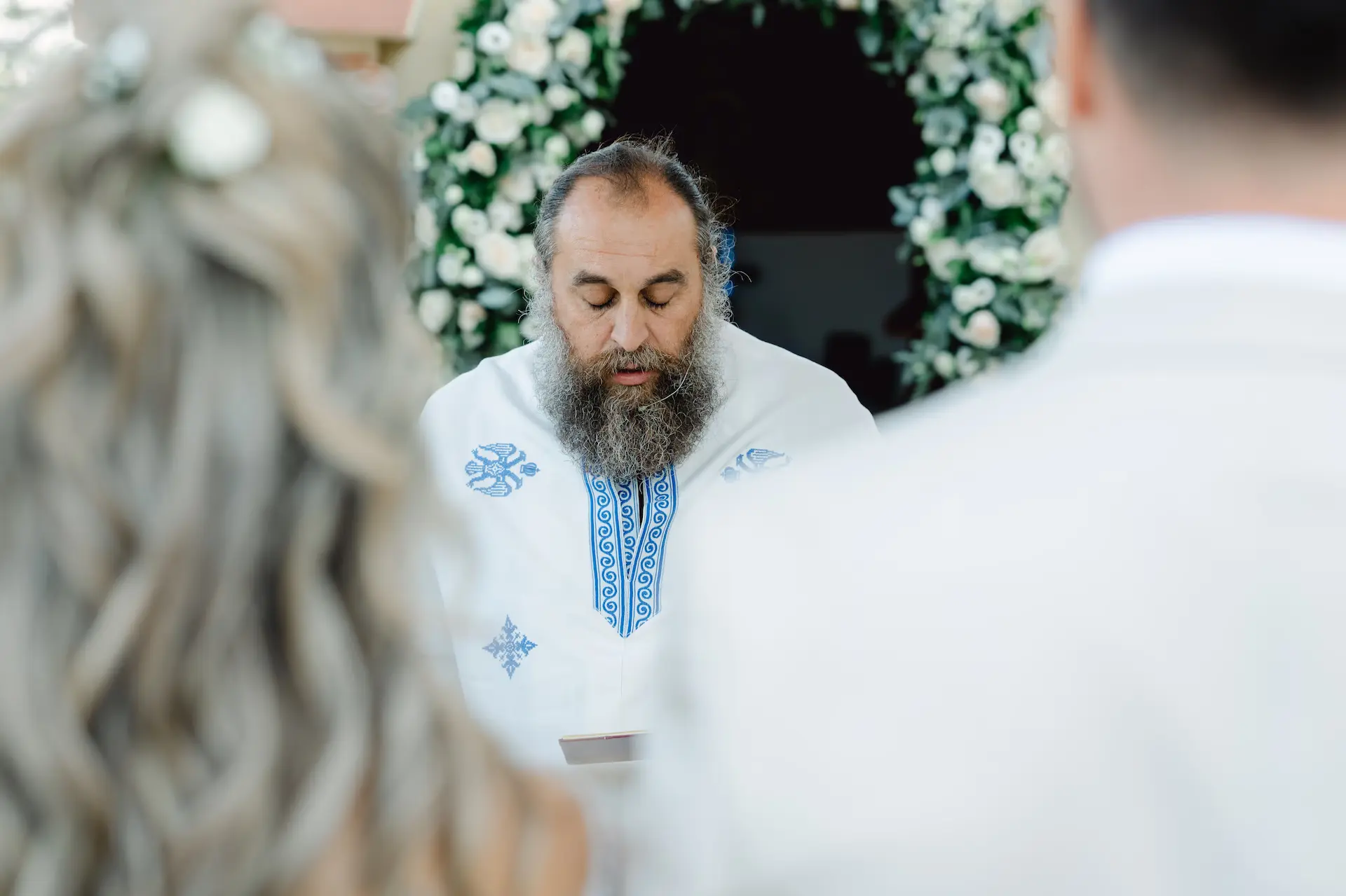 Greek Orthodox priest performing the wedding ceremony in a traditional church setting in athens