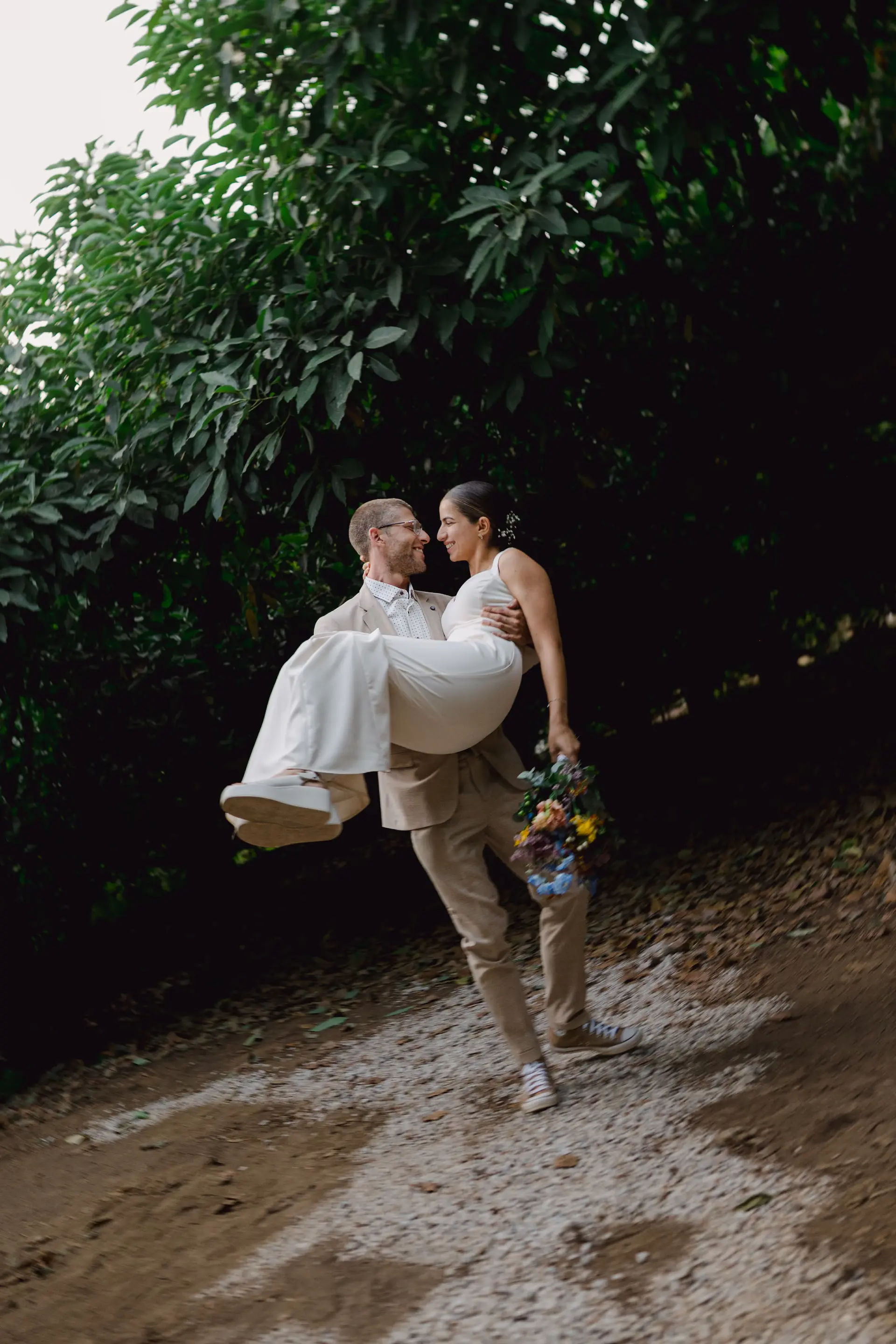 groom carrying romantic the bride in his arms