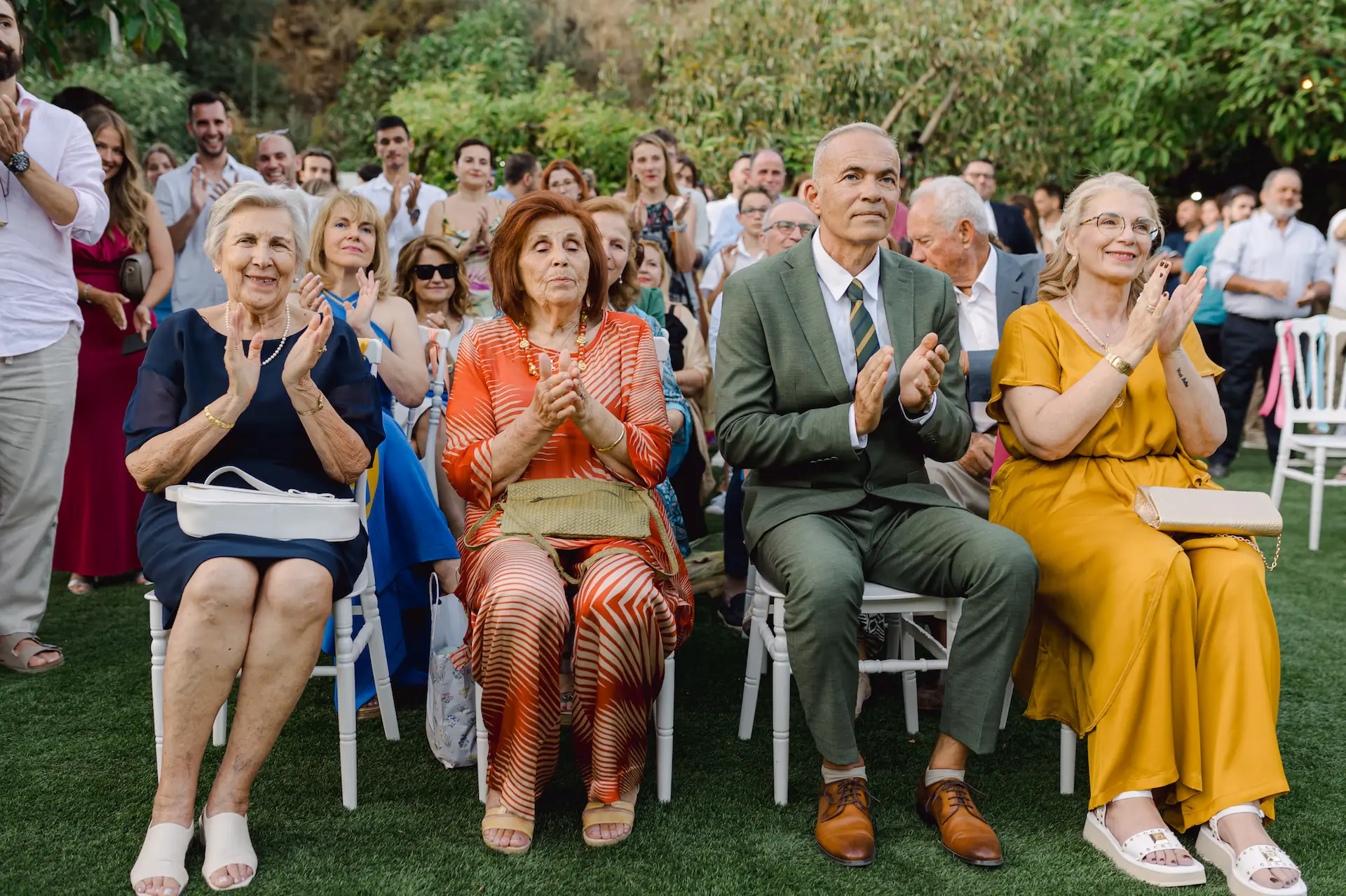 couple's family sitting in chairs clapping and smiling