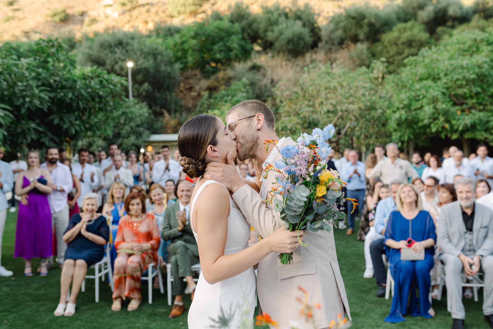 bride and groom kissing in front of their guests