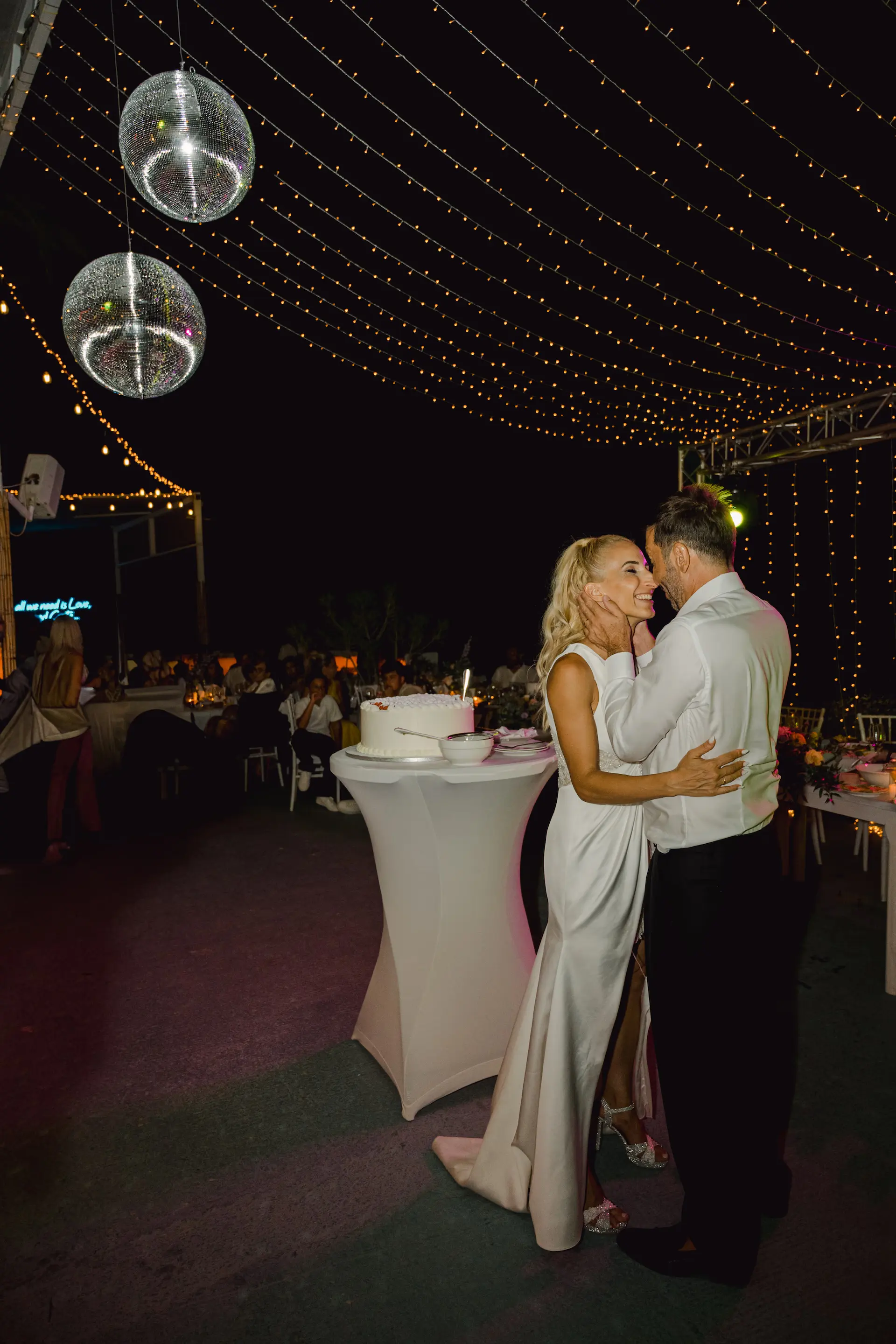 Authentic and unposed wedding photography: Newlyweds sharing a warm hug on the dance floor in Paleochora, Crete.