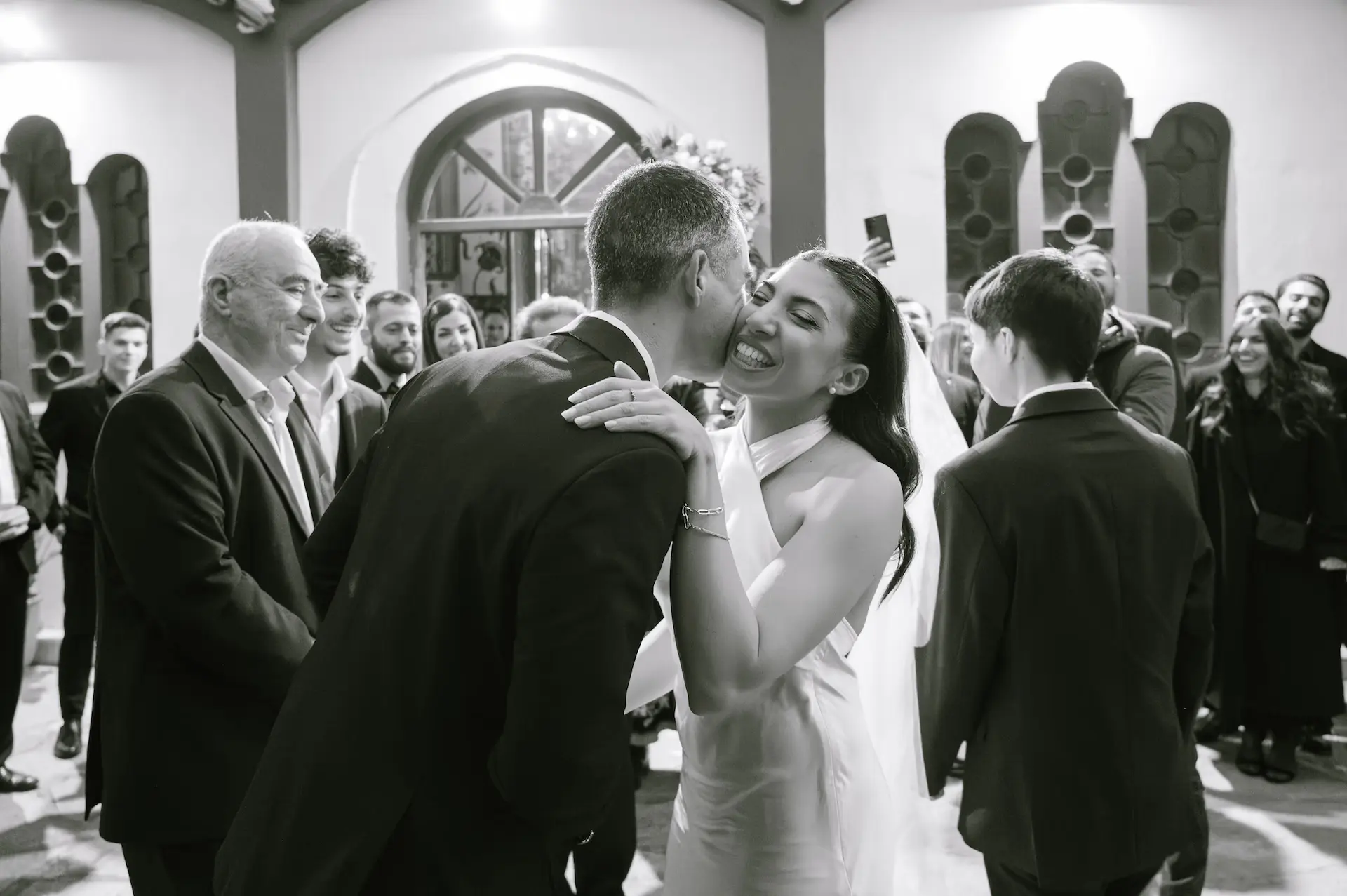 Emotional moment as the groom kisses the bride as she arrives to the church for the wedding ceremony.