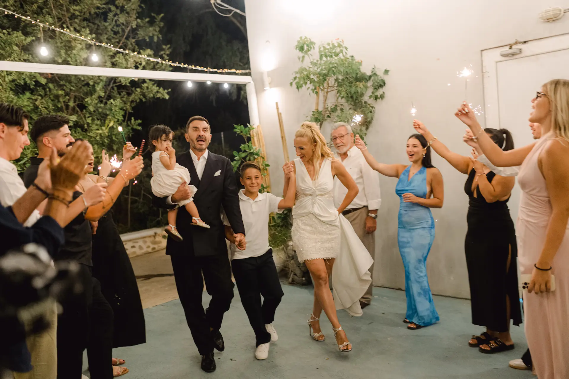 Energetic wedding reception entrance: The couple walking in front of cheering friends and family, capturing a moment of pure celebration.
