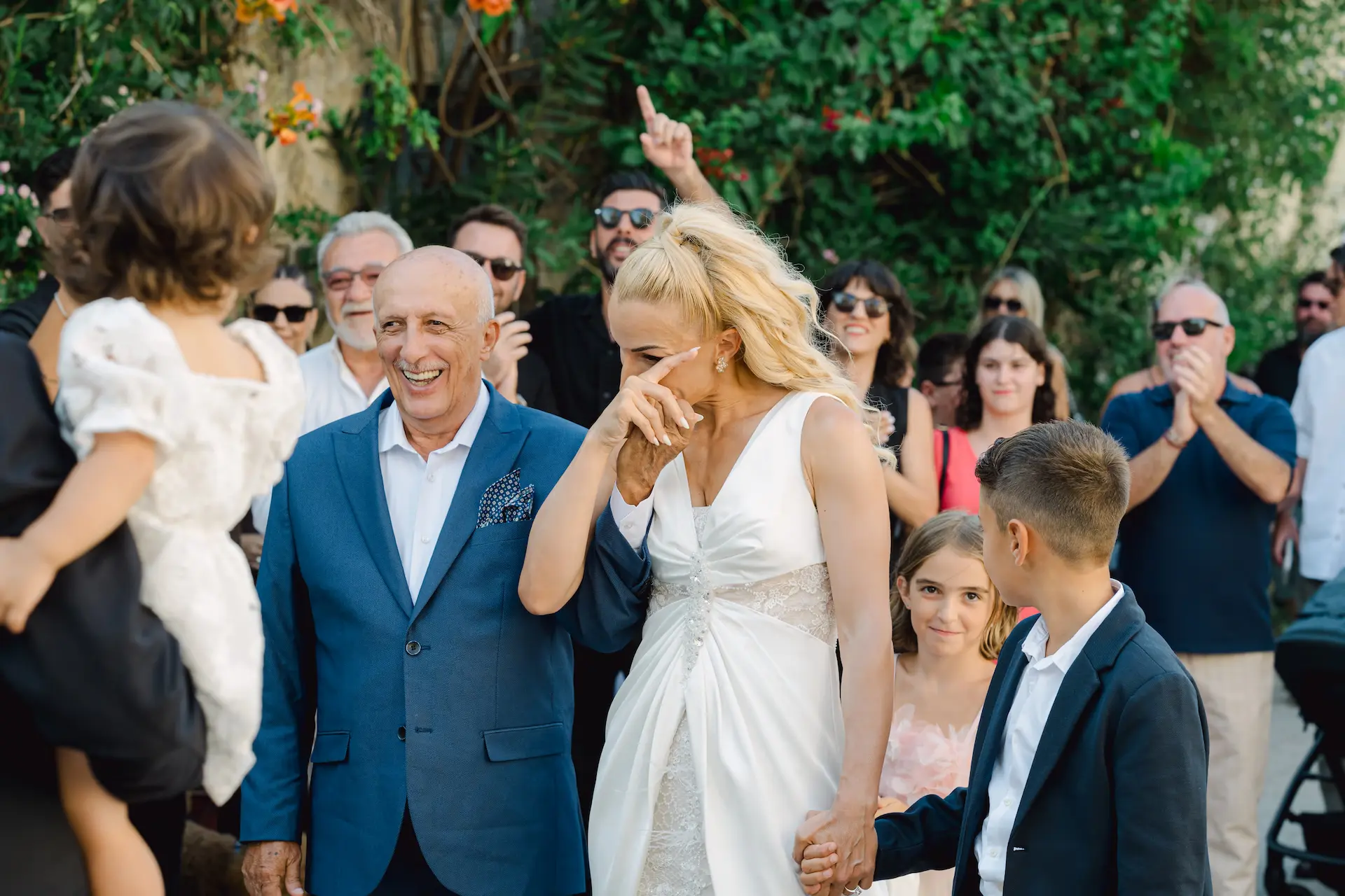 bride getting emotional when she sees the groom waiting for her in front of the church