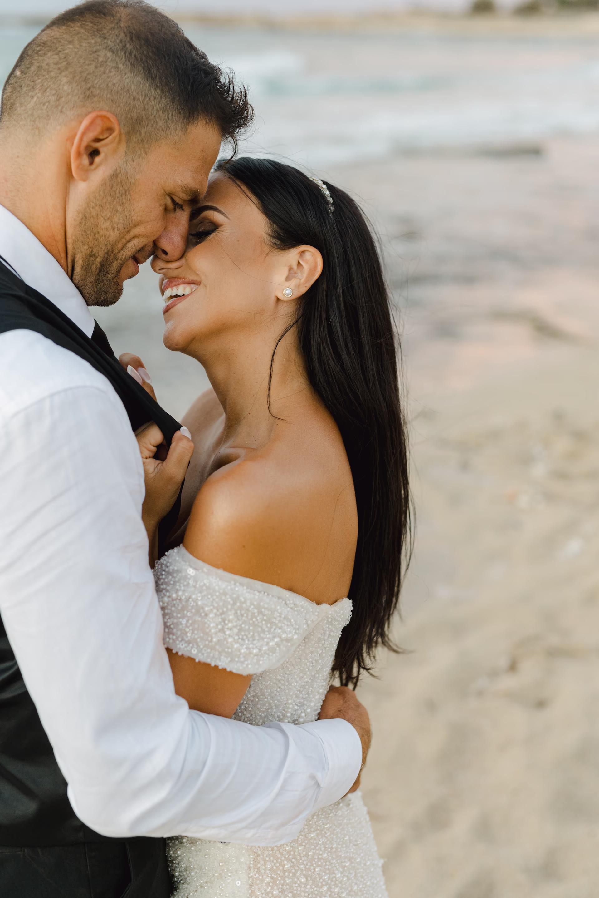 bride and groom intimate hugging on the beach of Stavros