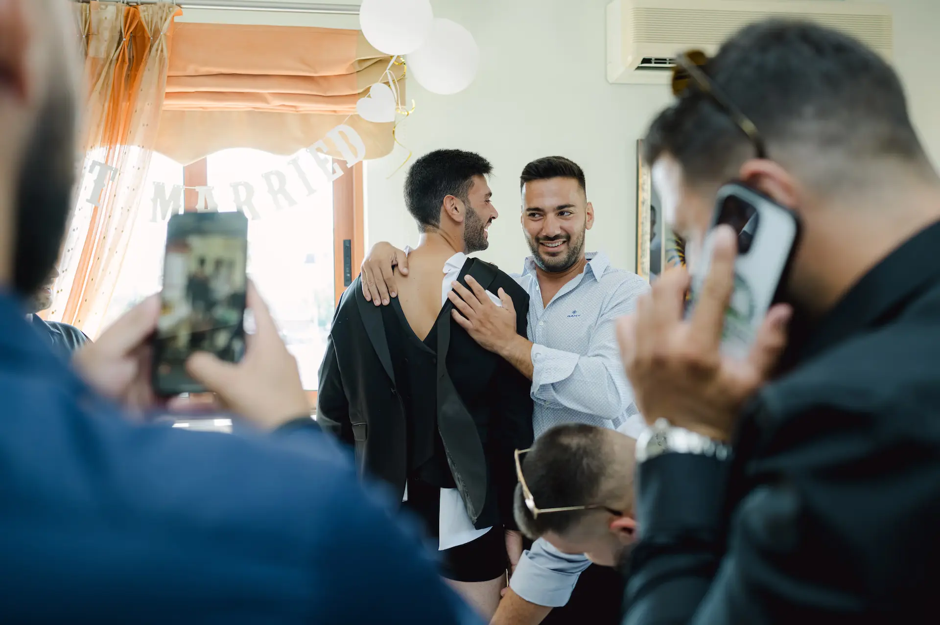 a group of men taking pictures of a man in a suit