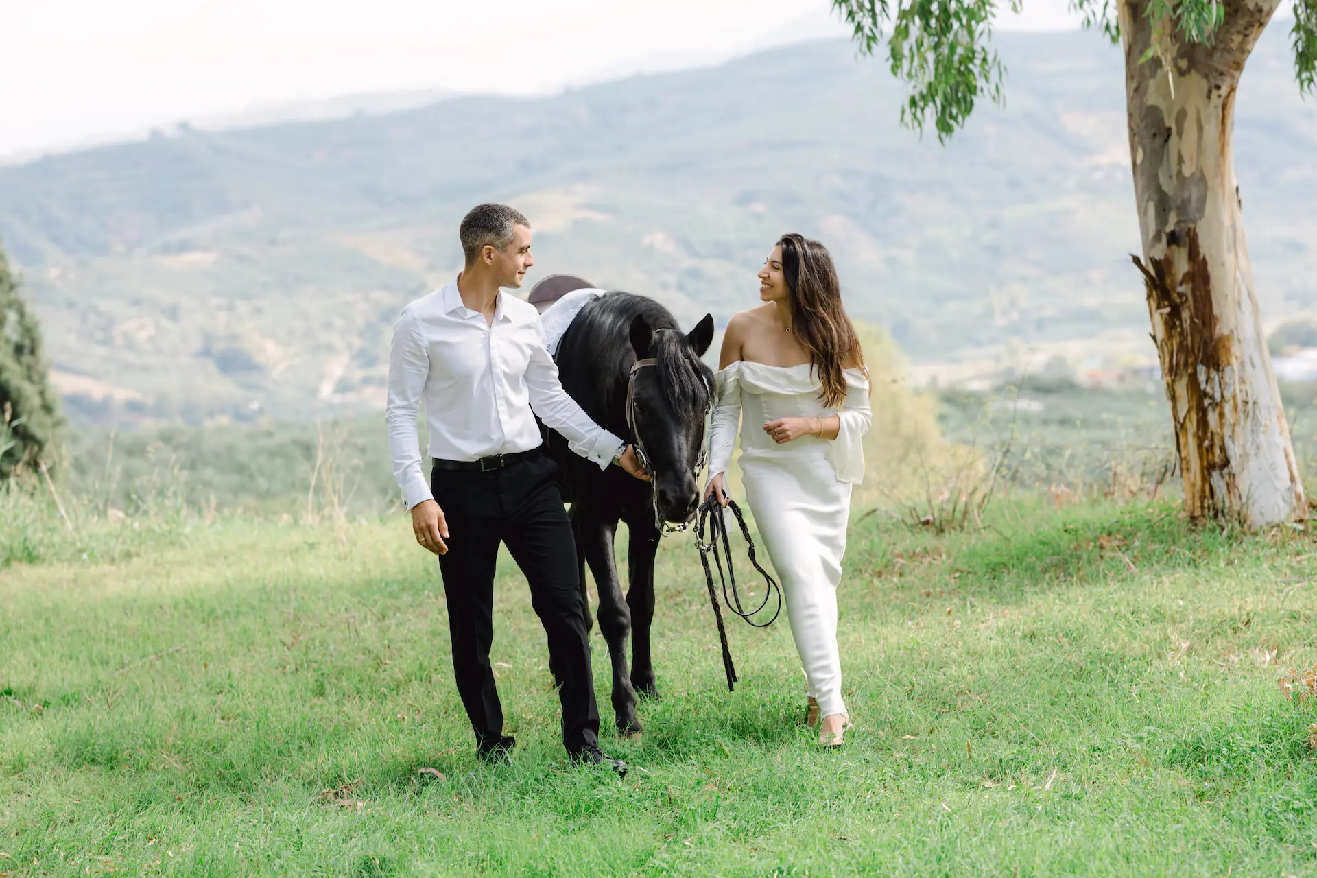 bride and groom walking with a horse during next day photoshoot