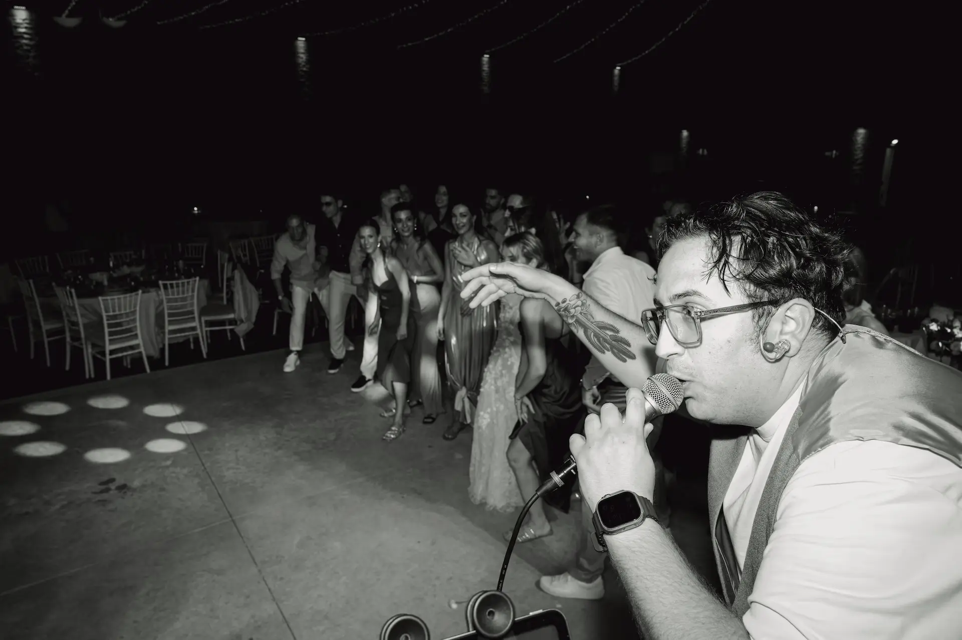 Freaktone band singer singing into a microphone with a crowd of people in the background