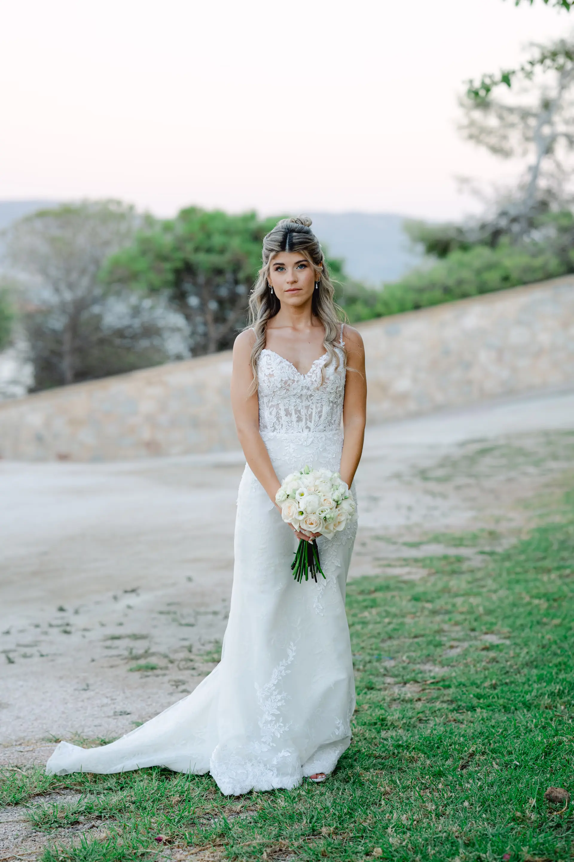 Stunning bridal portrait of the bride in her dress with a bouquet, captured in natural light