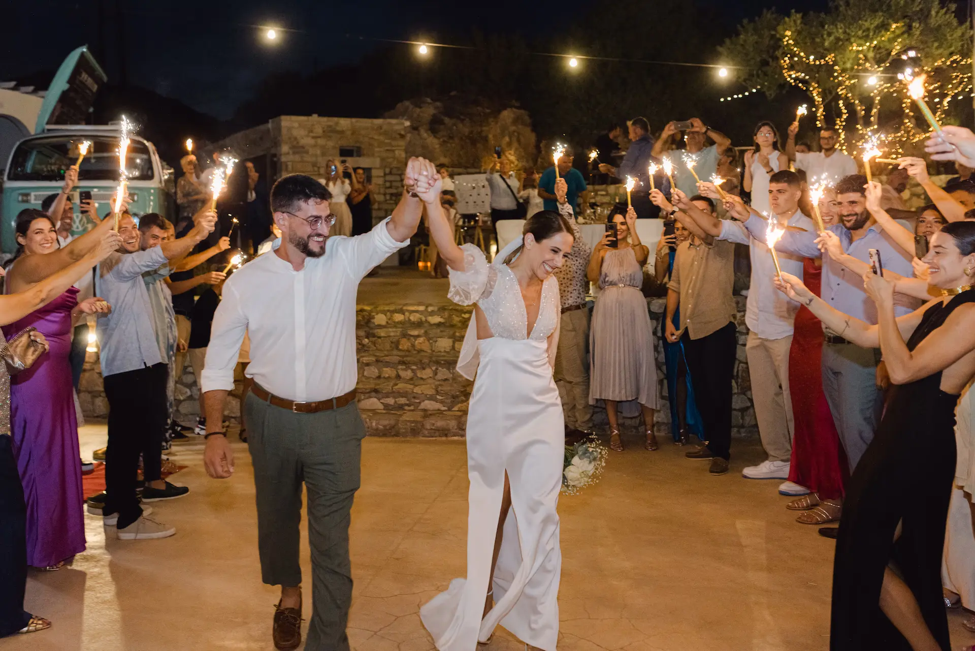 bride and groom holding hands and holding sparklers during their entrance