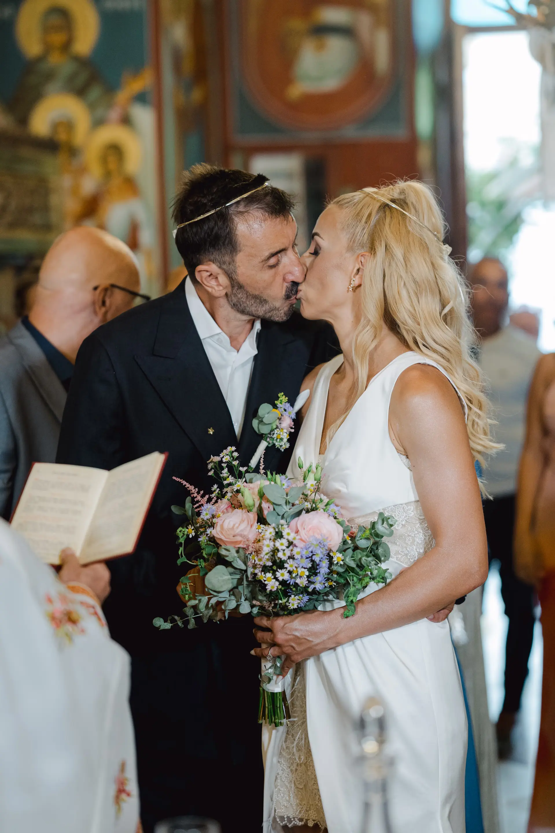 Intimate moment of the bride and groom kissing during their wedding ceremony, capturing their deep connection and authentic joy.
