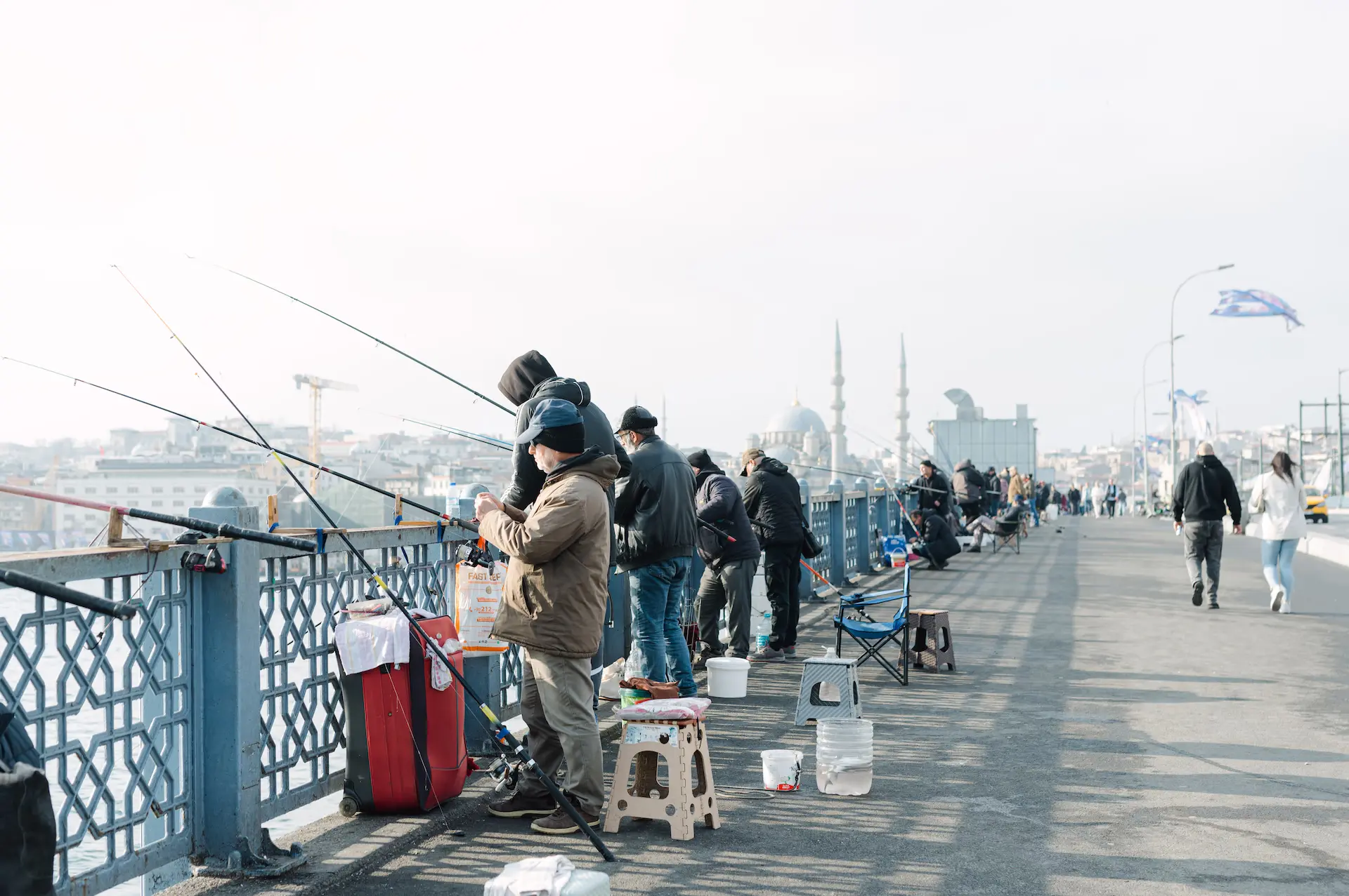 a group of people fishing on a bridge