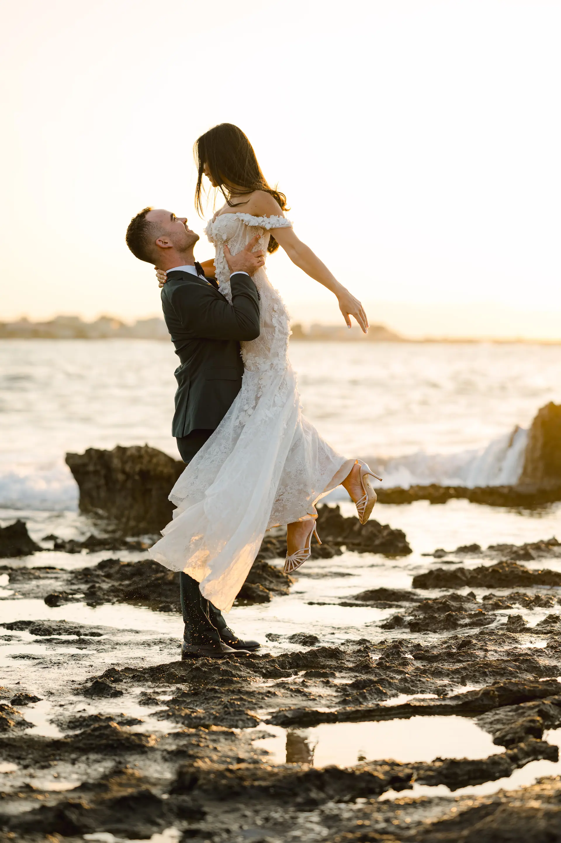 Groom lifting the bride on the beach of Stavros, Chania.