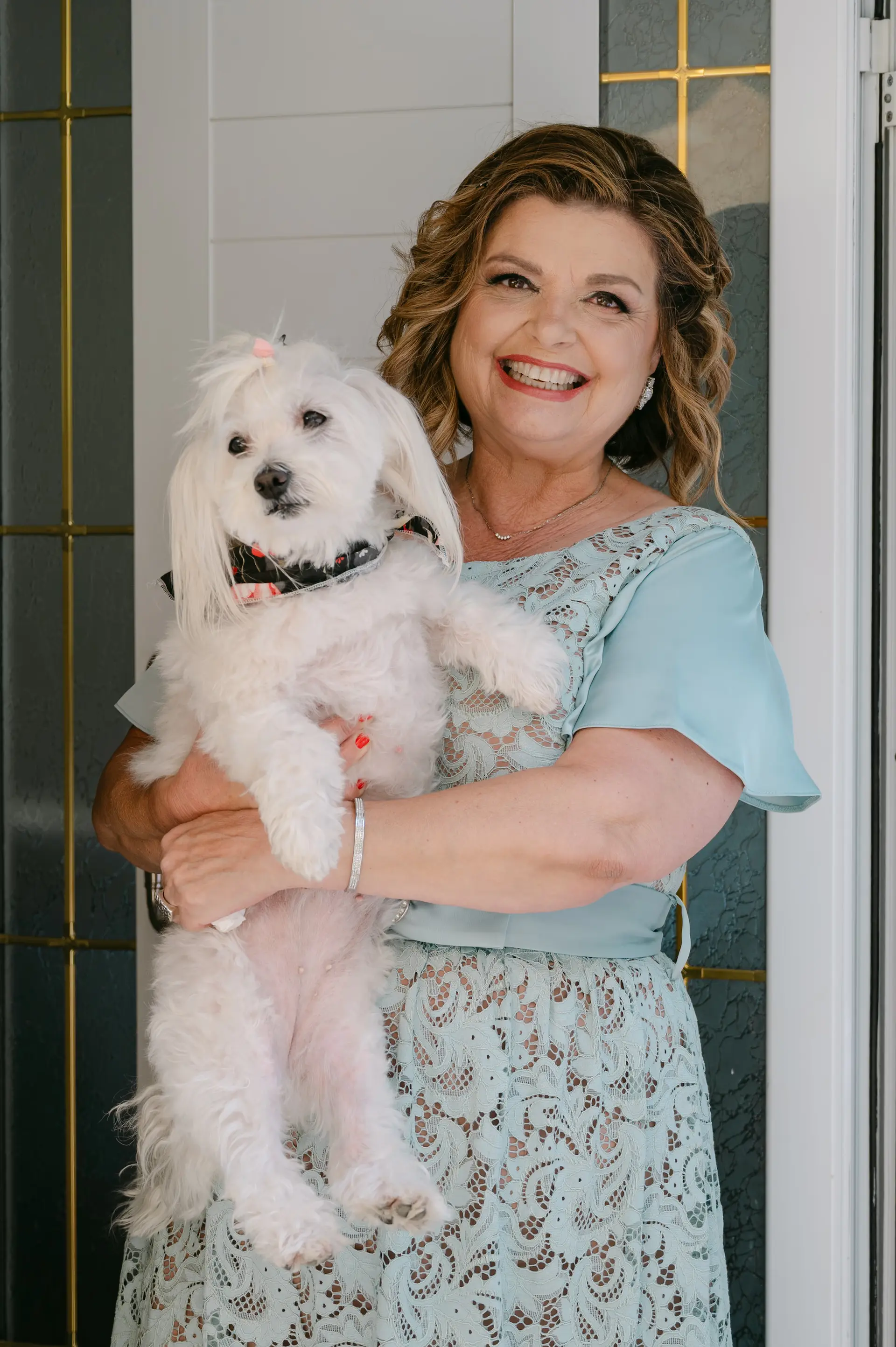 groom's mother holding happily their dog