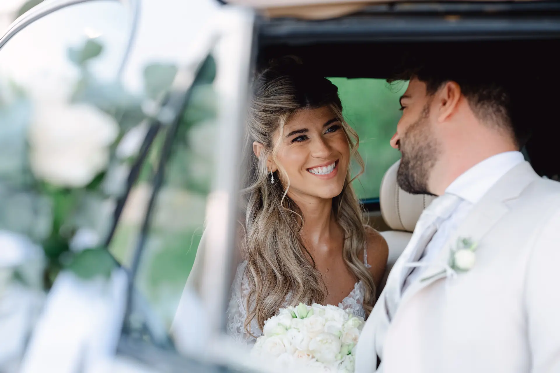 A stylish bride in a vintage car, capturing the sophisticated atmosphere of a destination wedding