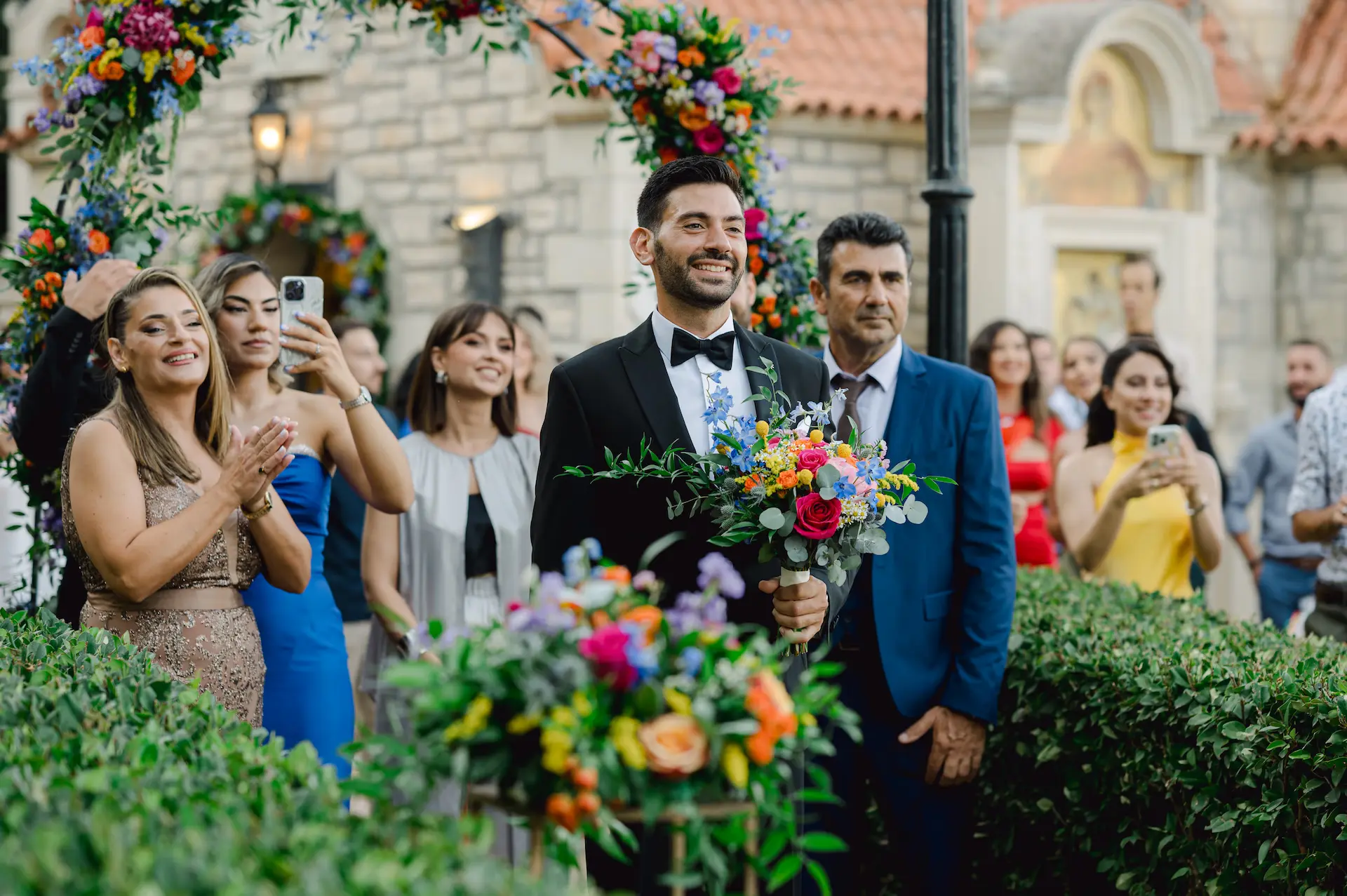 a man in a suit holding flowers