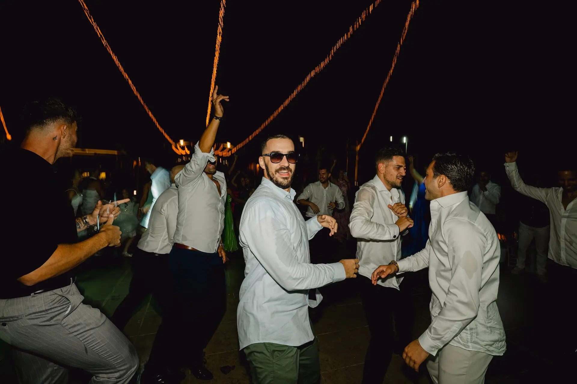 a group of men dancing at night in the dancefloor