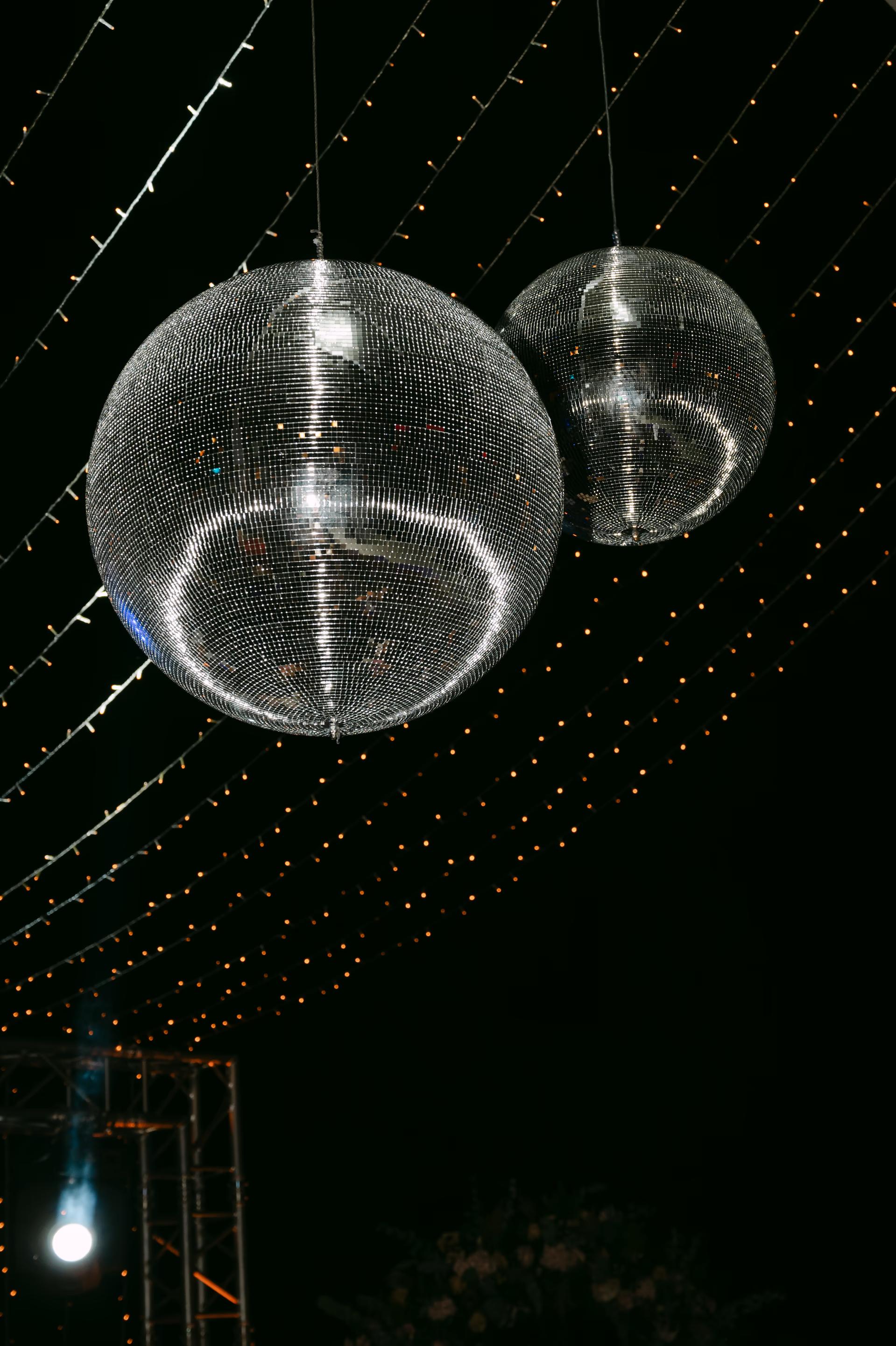 Glamorous party atmosphere in a Crete venue with disco balls reflecting light across the dance floor.