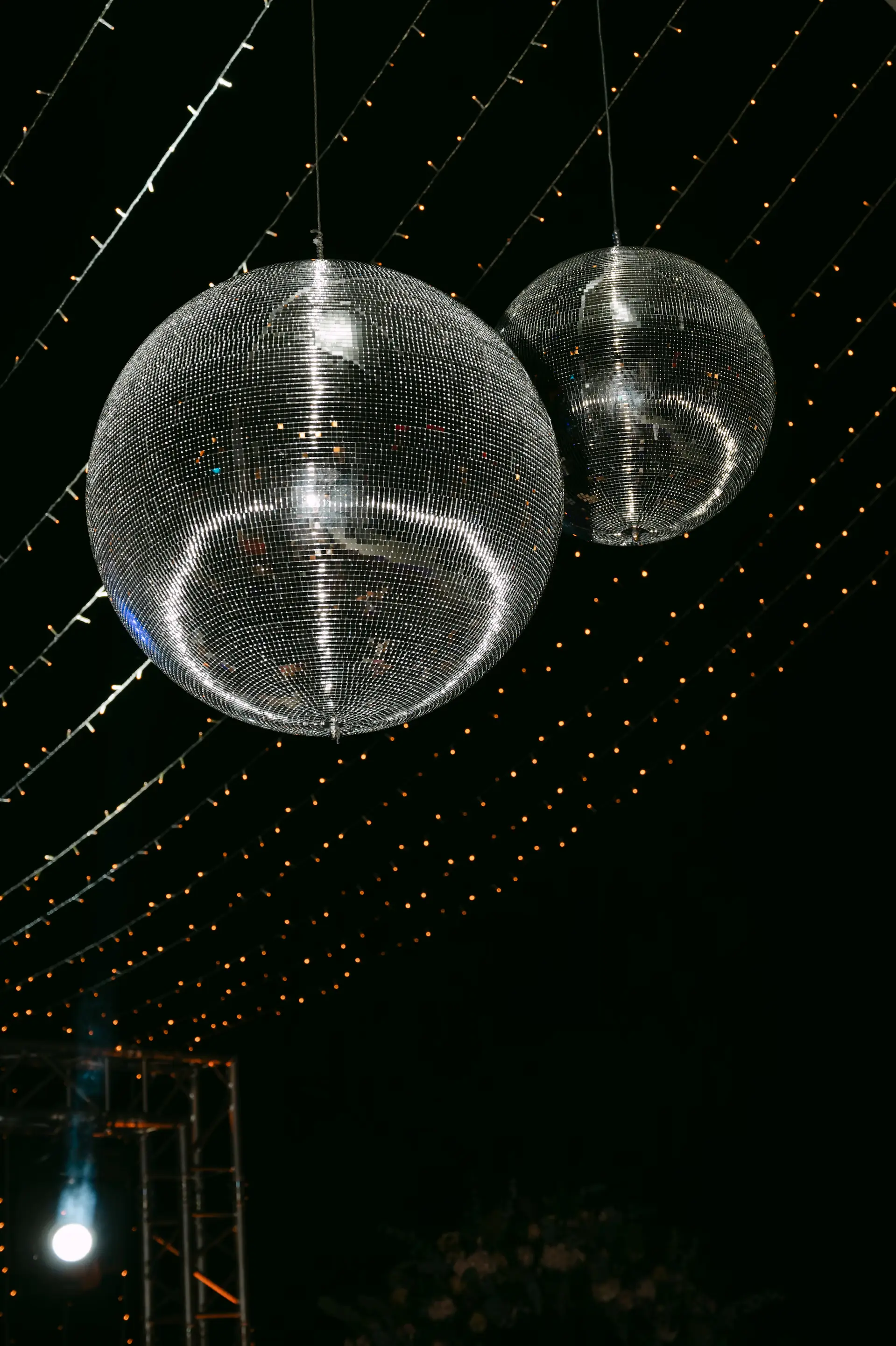 Sparkling disco balls and fairy lights decorating the outdoor dance floor, capturing the vibrant energy of a Cretan wedding party.