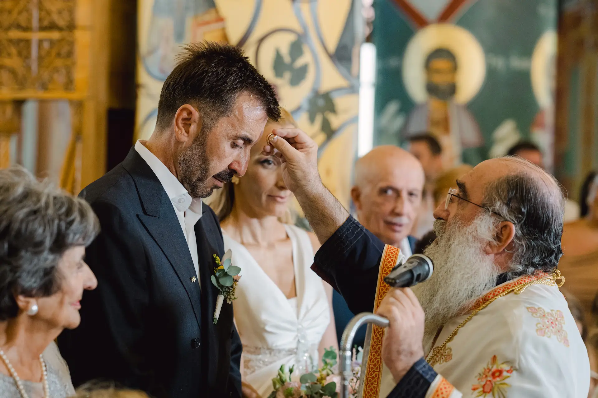 Orthodox priest performing the exchange of rings during the wedding ceremony, capturing a sacred and traditional moment.