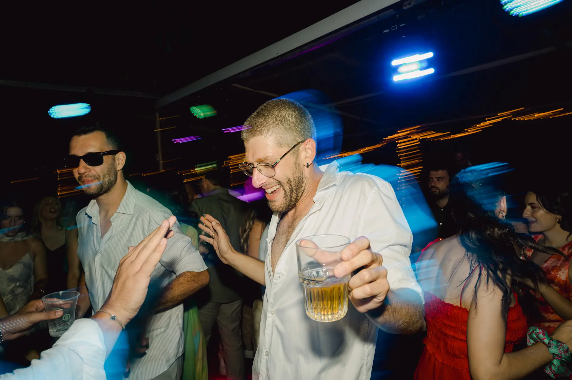 groom dancing during wedding party holding his beer