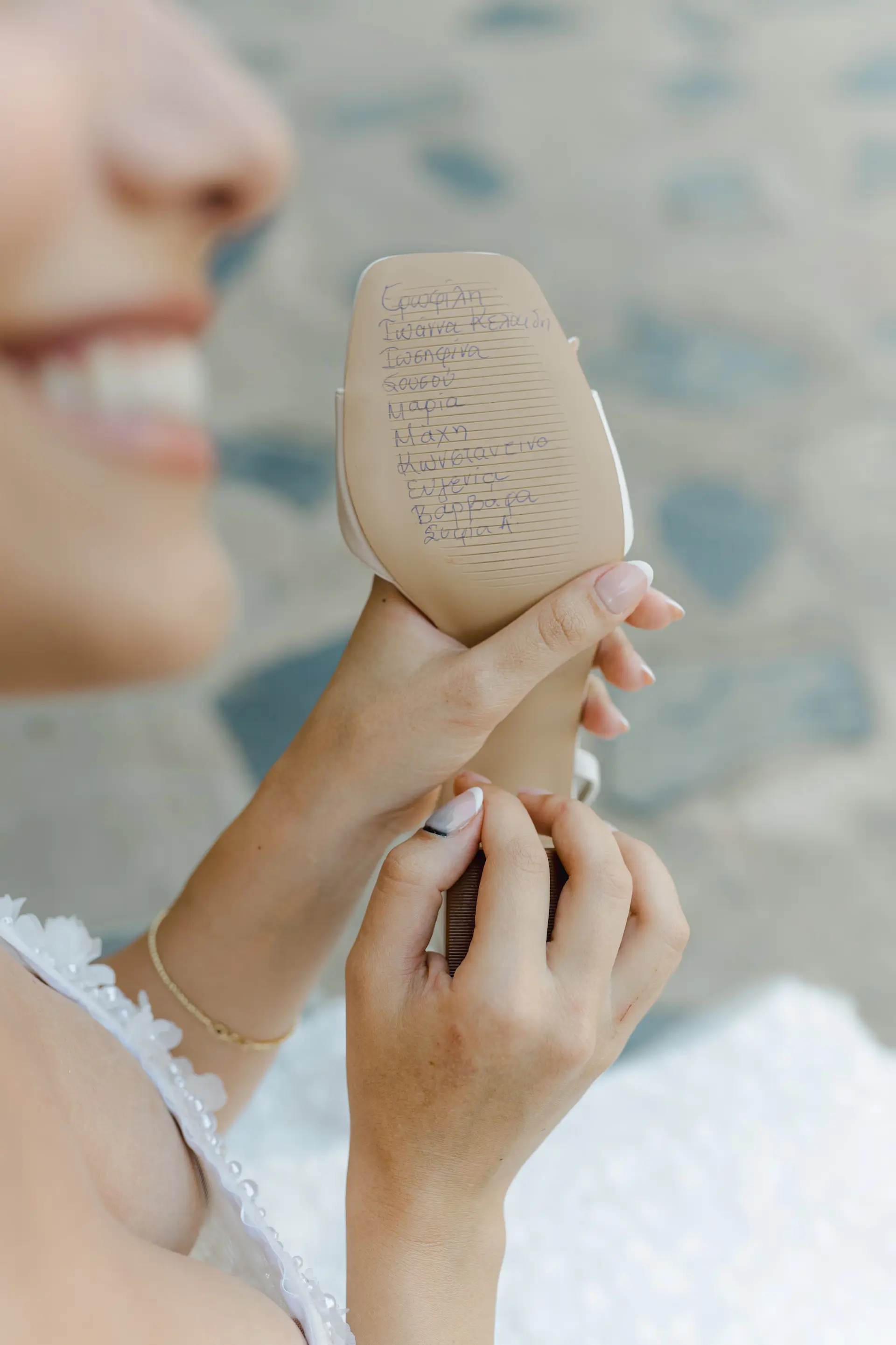 bride holding her show with her friends names written on it