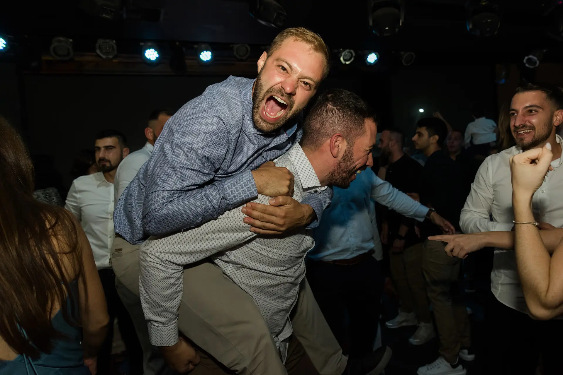 a man carrying another man during wedding party