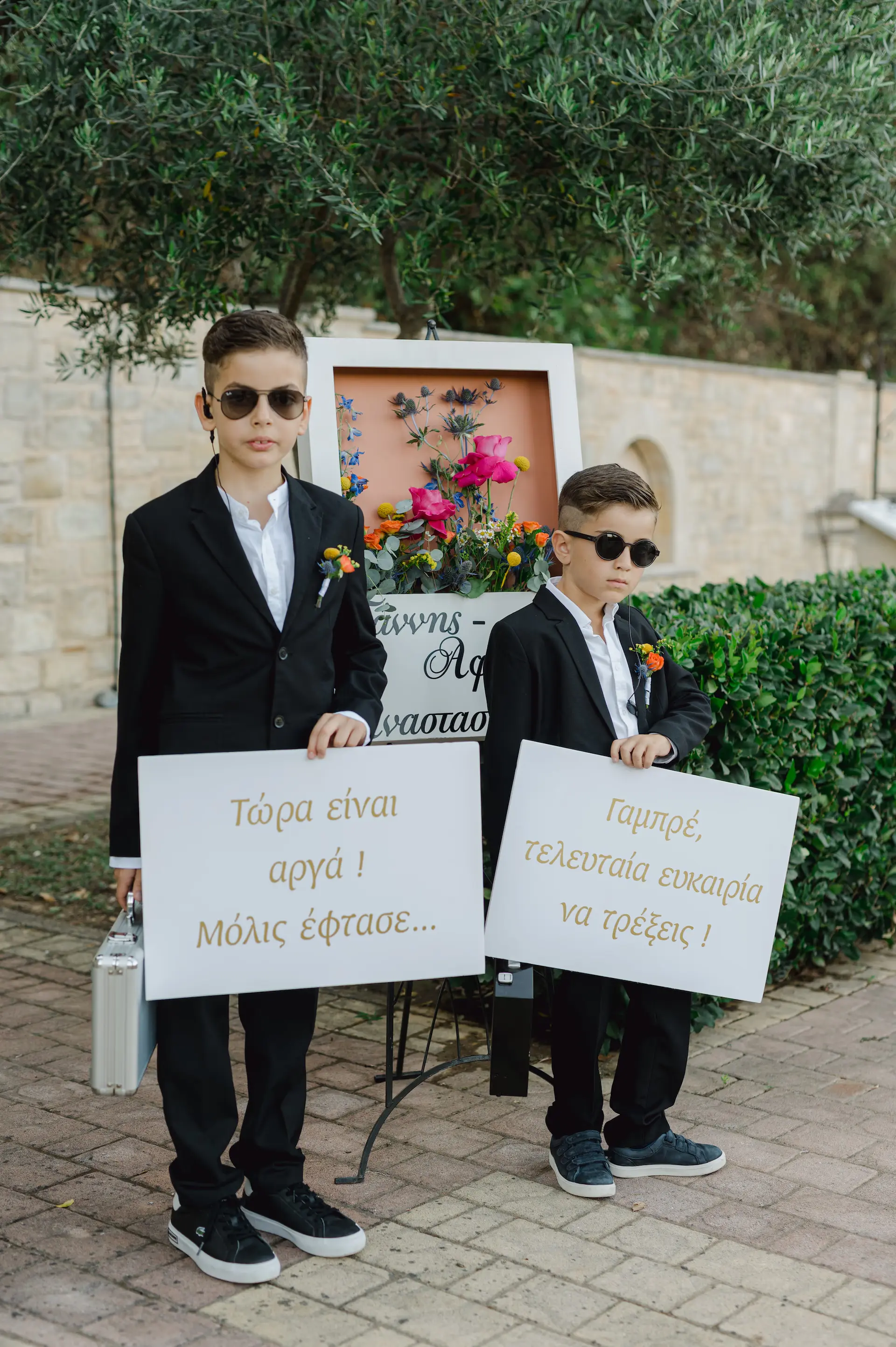 two boys in suits holding signs