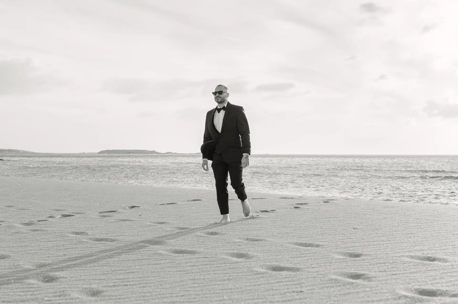groom portrait walking on a beach