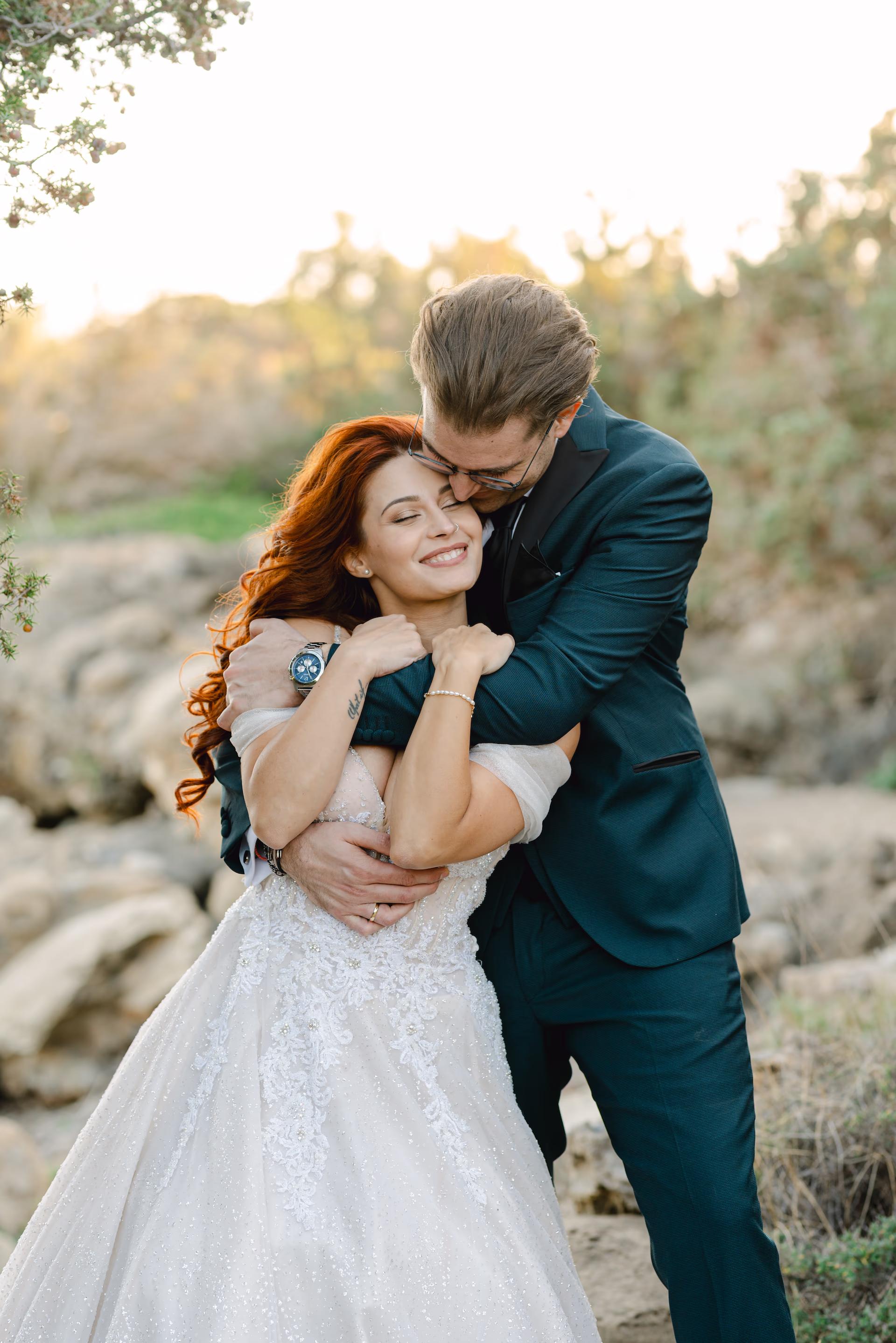 groom gently kissing bride in a beautiful beach scenery