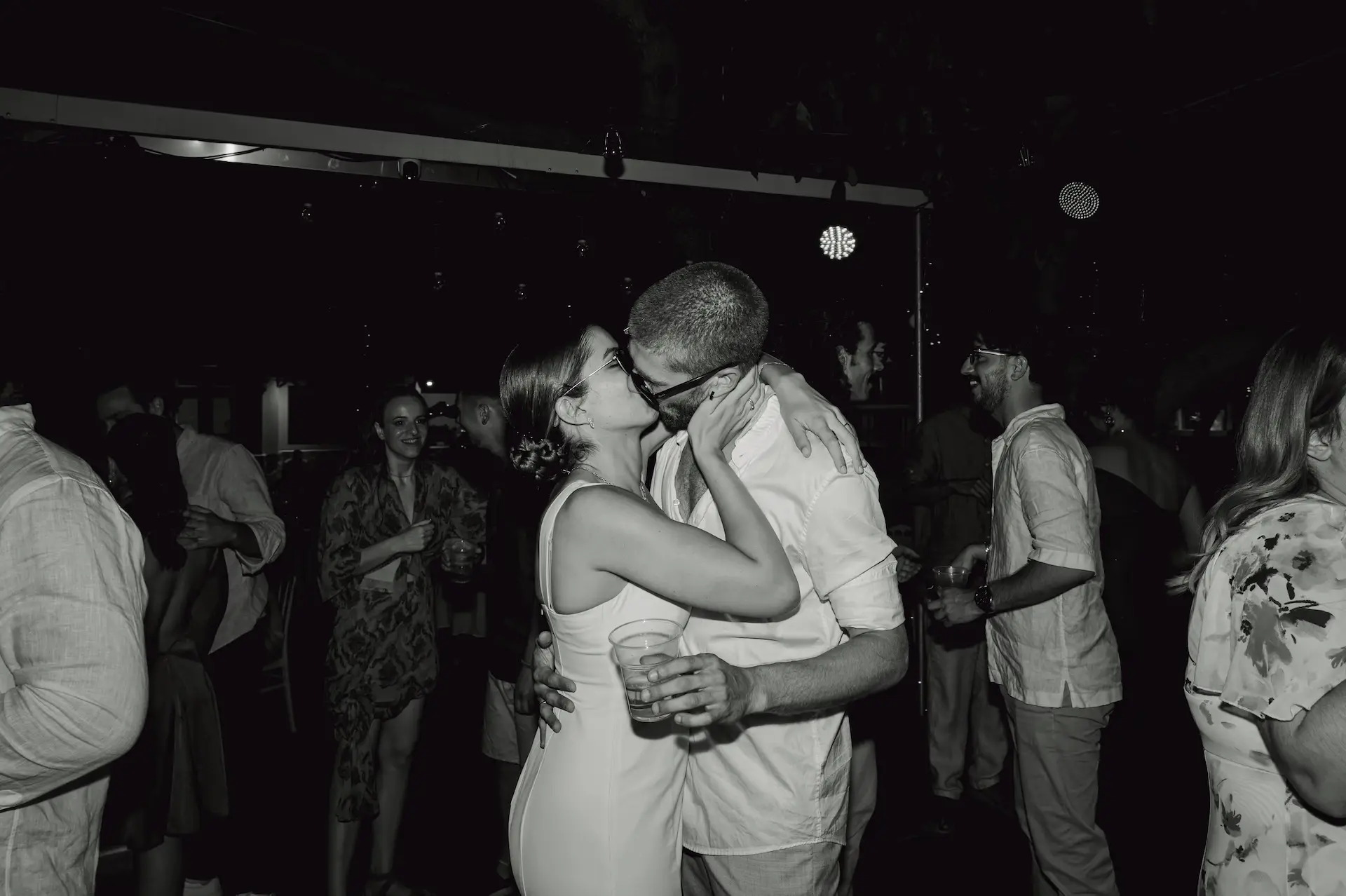 bride and groom kissing in the middle of the dance floor