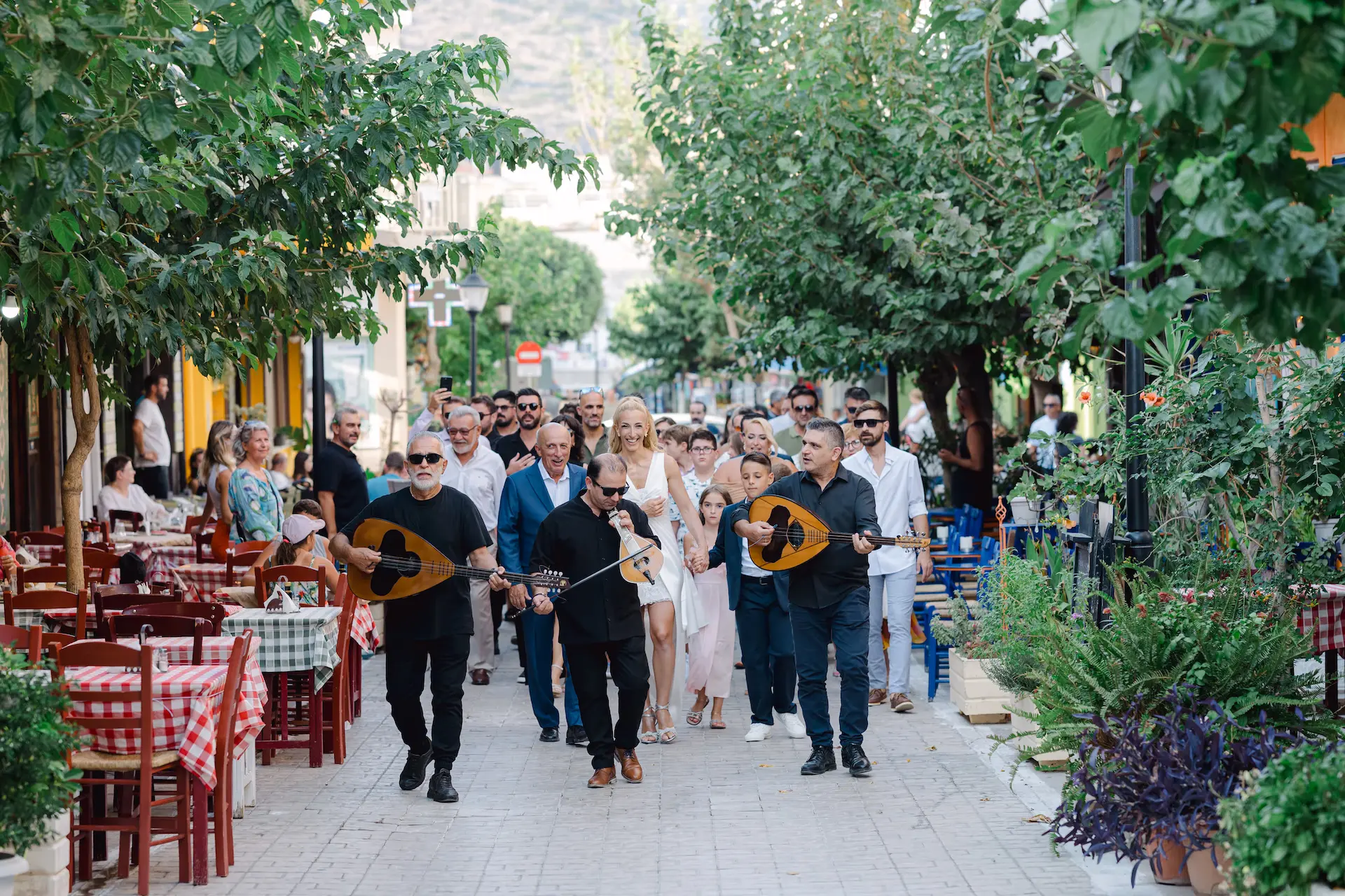 Traditional Cretan wedding procession in Paleochora, with the bride walking to the church accompanied by family and musicians playing local instruments.