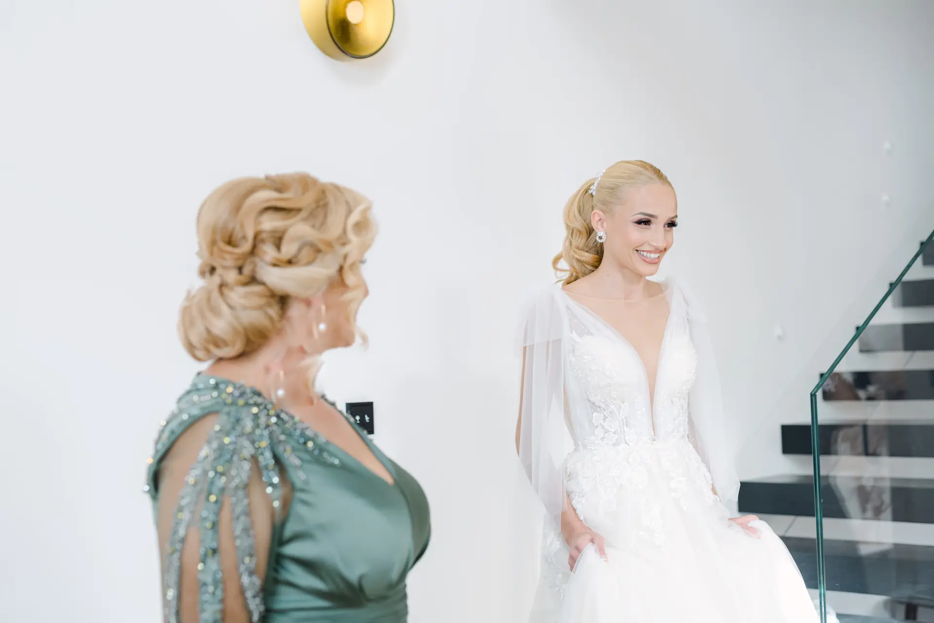 bride in her wedding dress while her mother looks at her