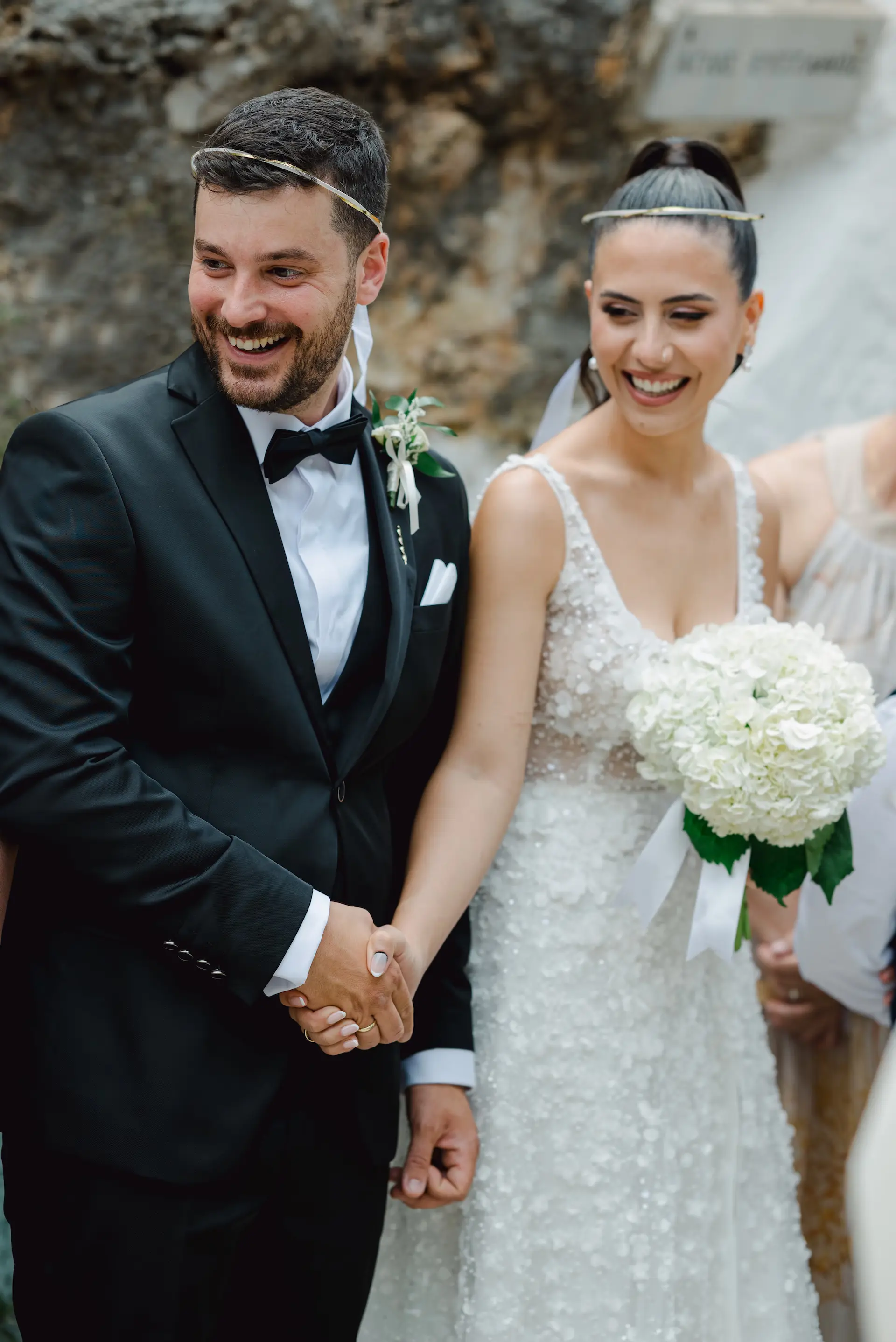 portrait of bride and groom holding their hands happily
