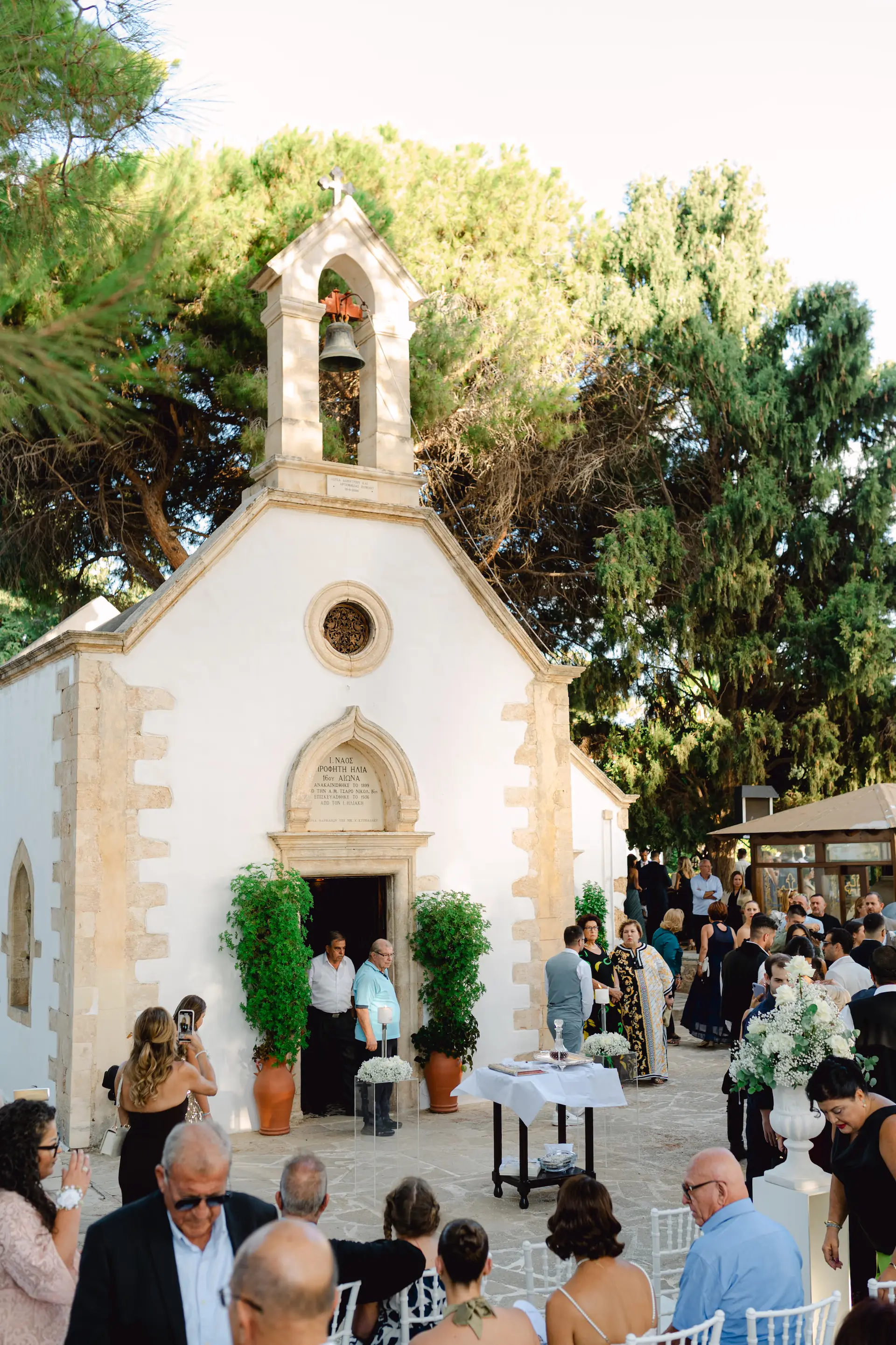 Picturesque outdoor wedding ceremony at a Greek chapel in Tafous Venizelon Chania, with guests gathered 