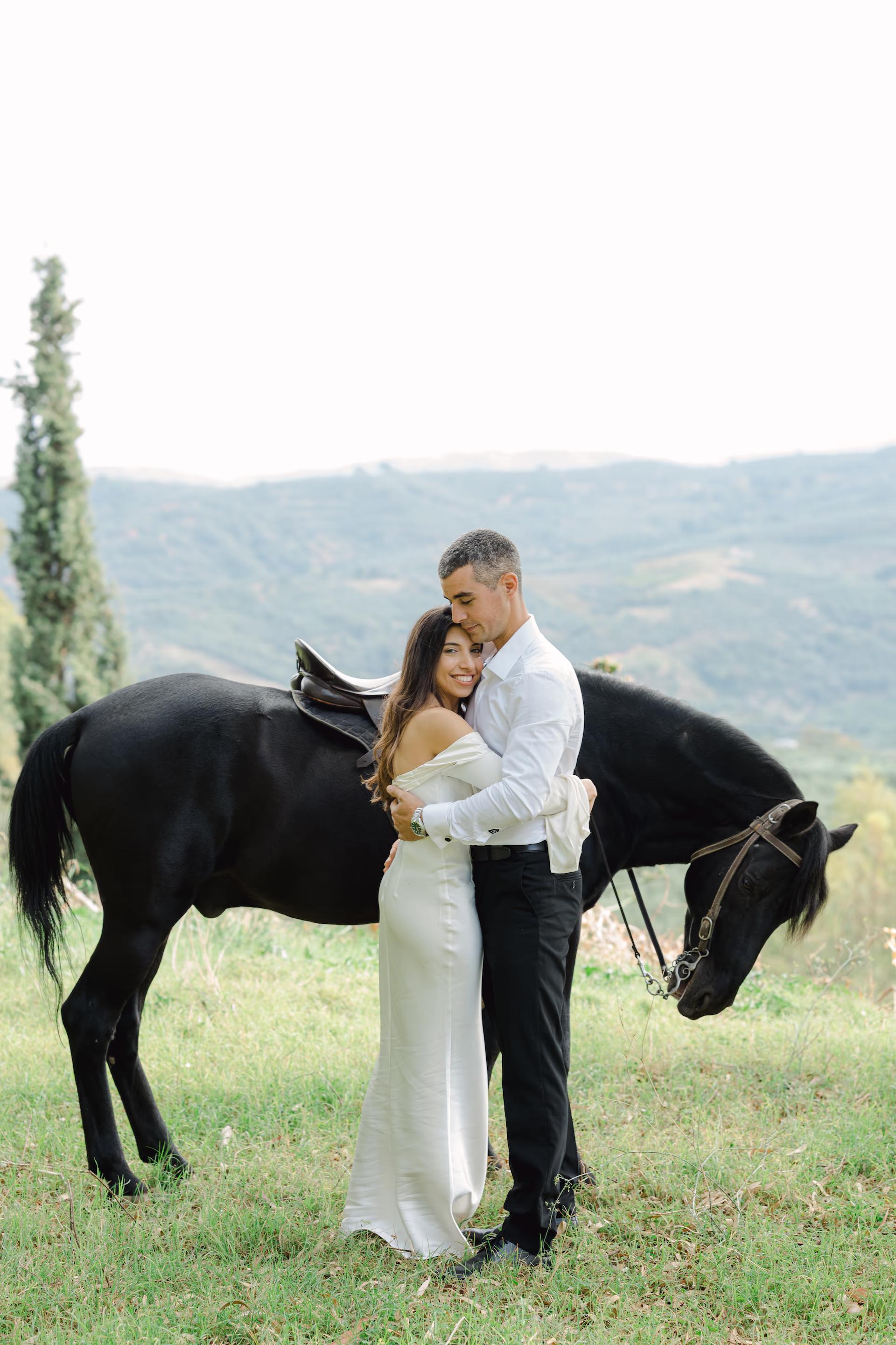 Romantic bride and groom hugging next to a majestic horse during their Next Day photoshoot