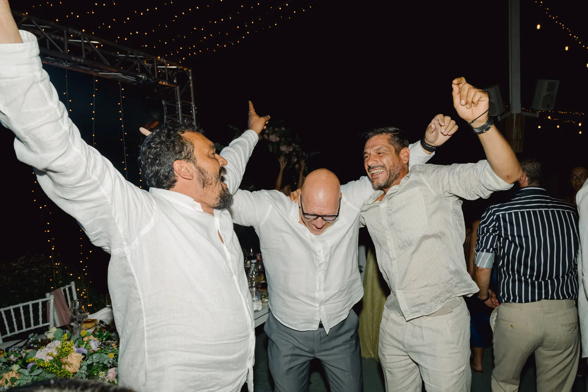 a group of men dancing at the wedding party