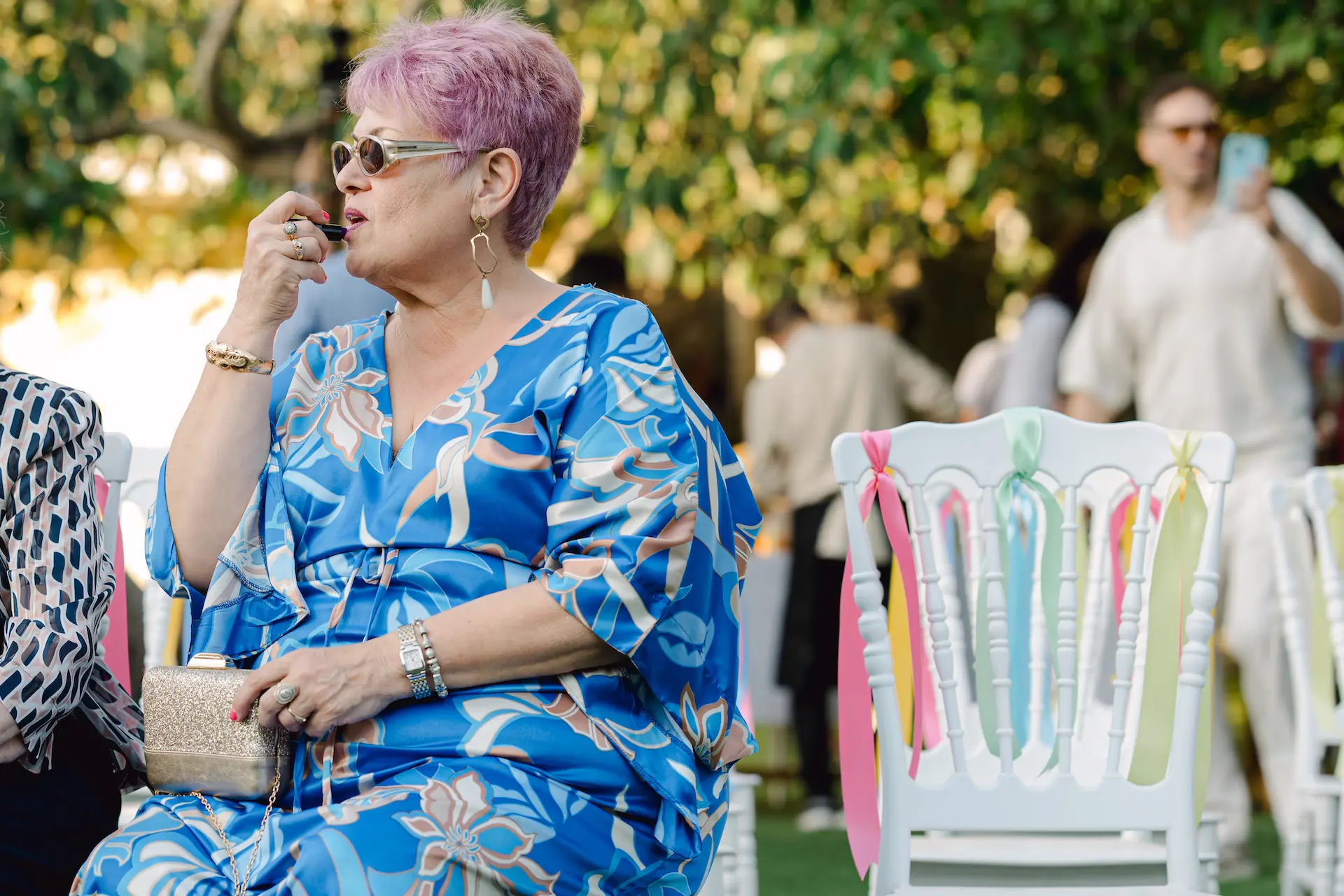 a woman sitting on a chair putting on her make up
