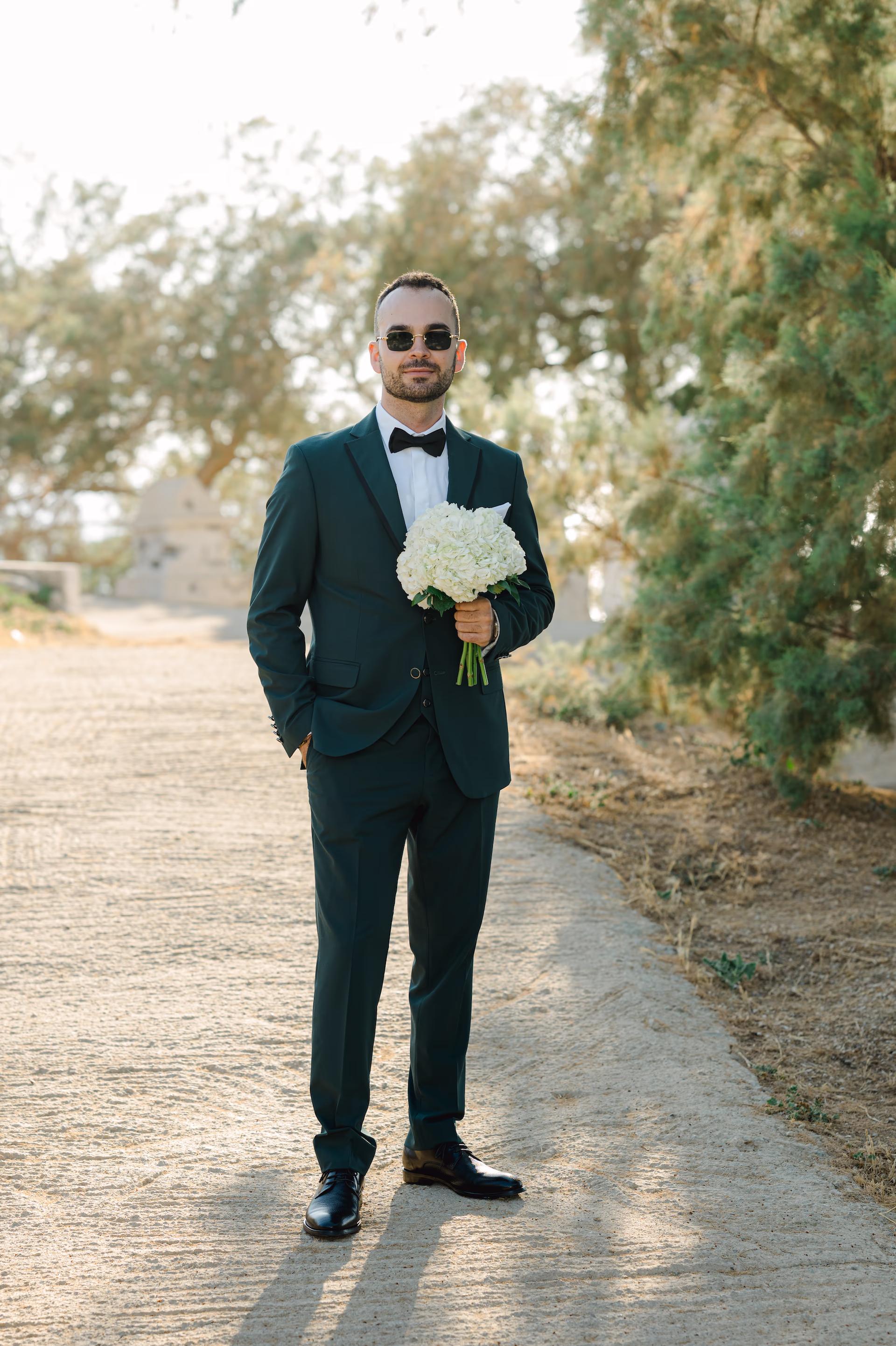 groom holding a bouquet of flowers waiting for the bride