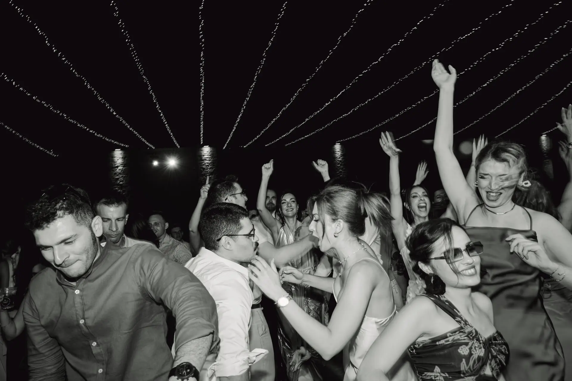 a group of guests dancing at the wedding party