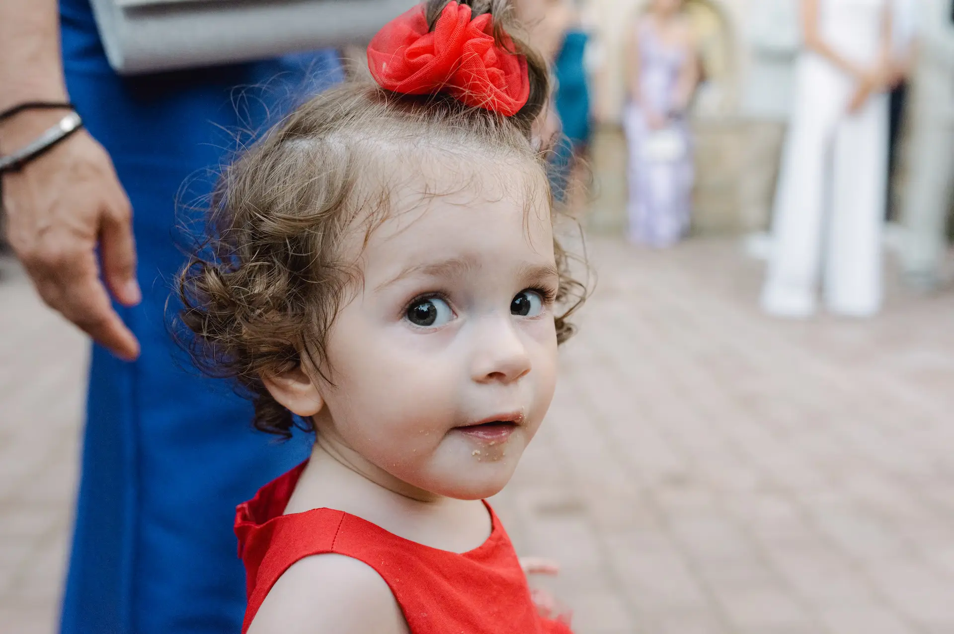 a child with a red bow on her head