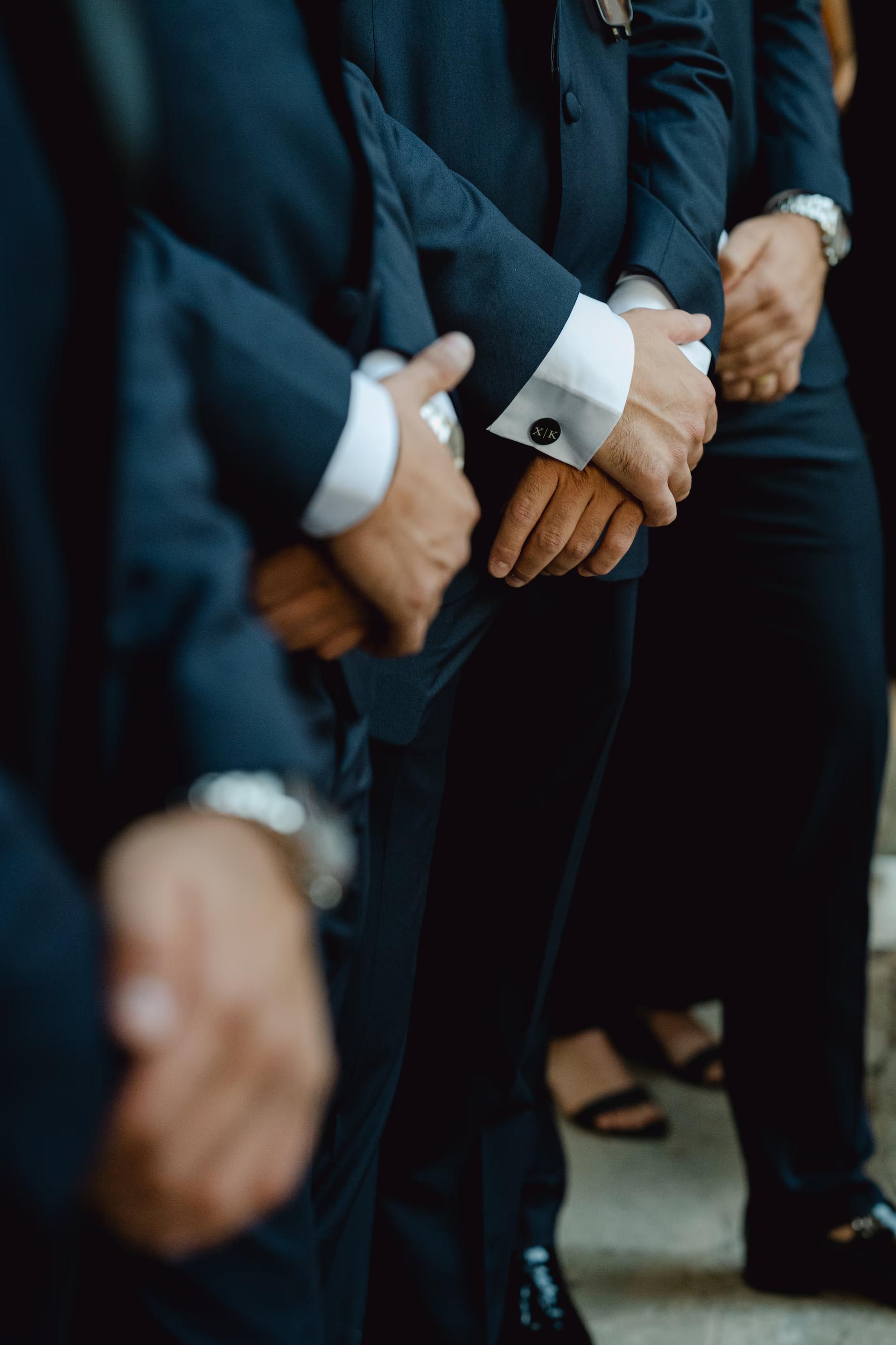 artistic photo of groomsmen holding hands