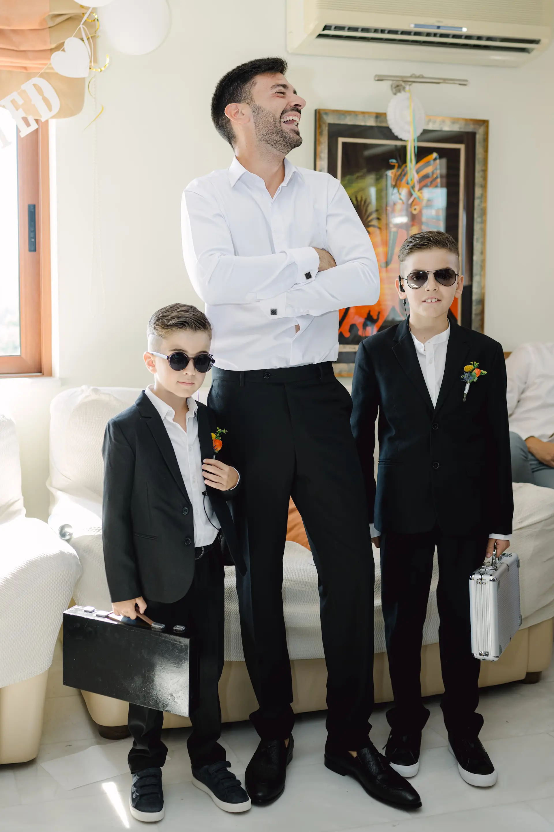 a man and two boys in suits