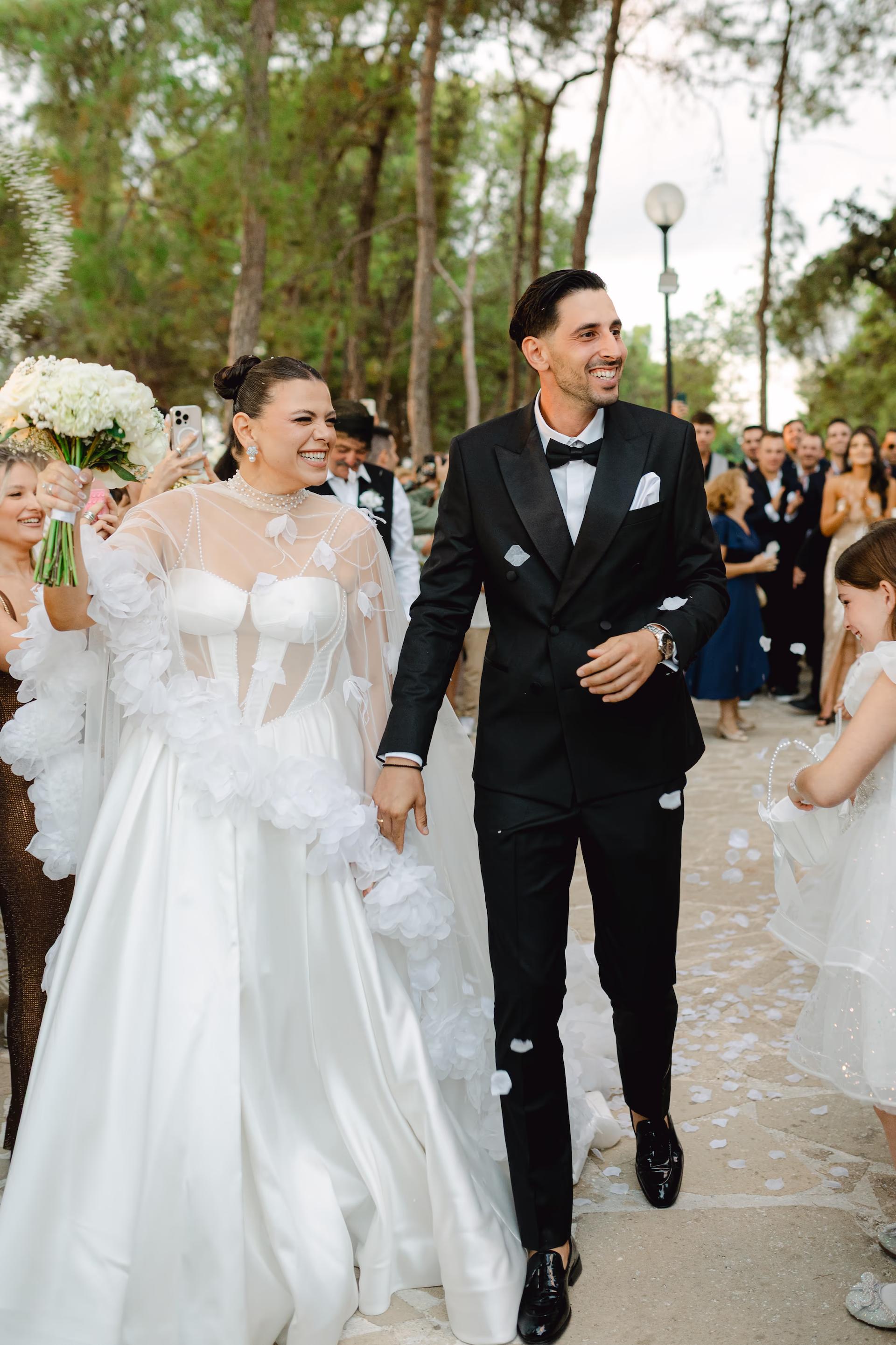 Bride and groom walking down a path after wedding ceremony with guests