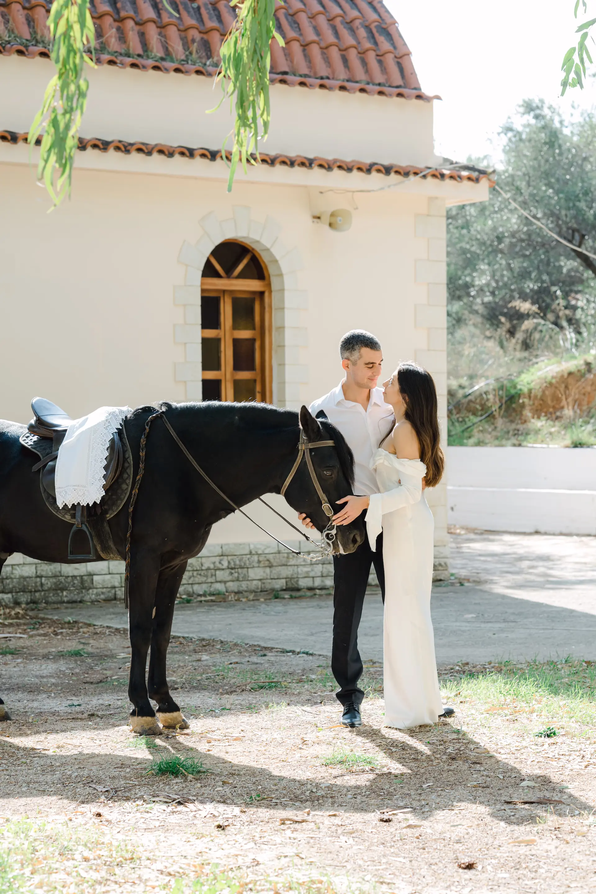 a man and woman standing next to a horse