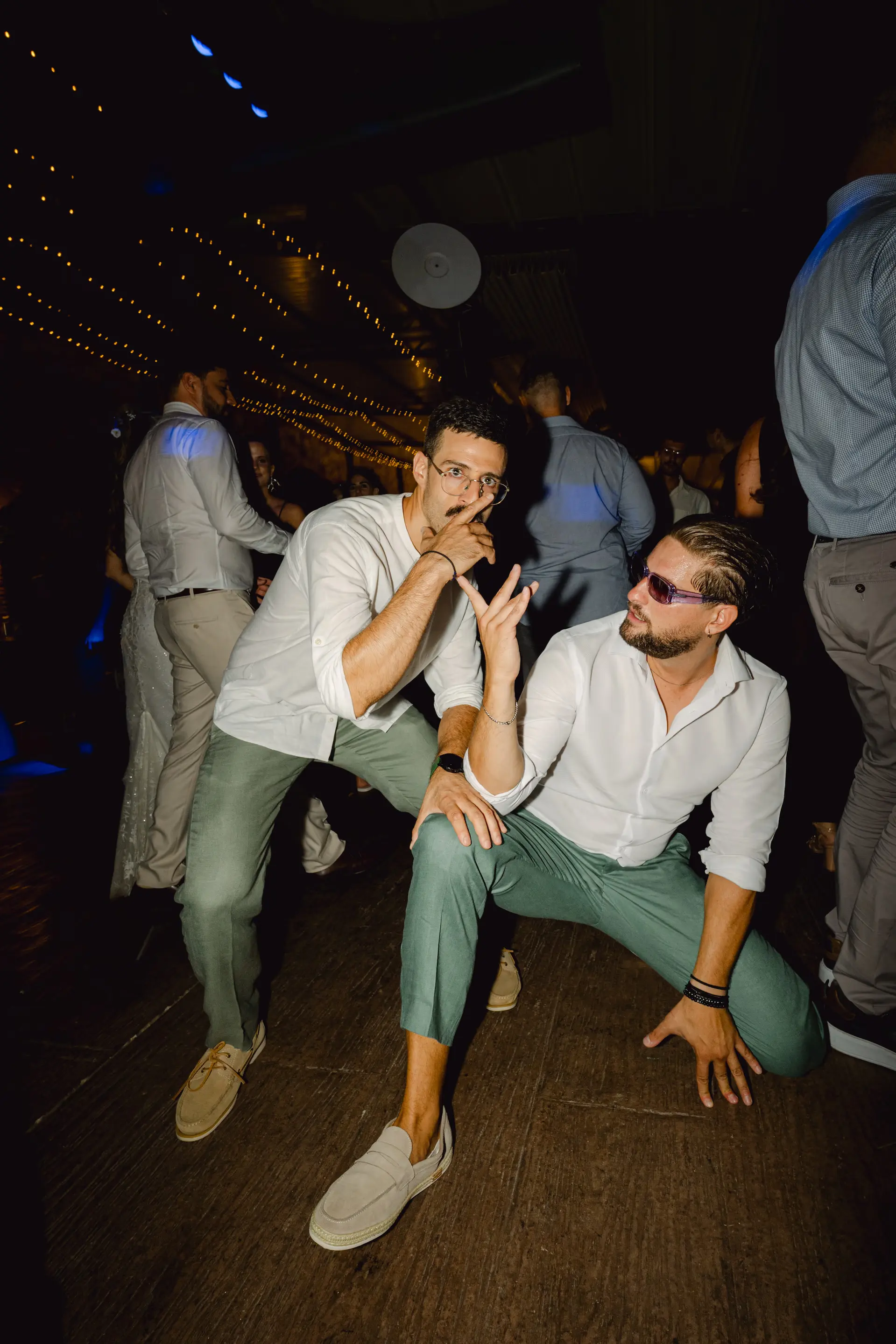 Candid shot of wedding guests enjoying a lively dance party during the reception
