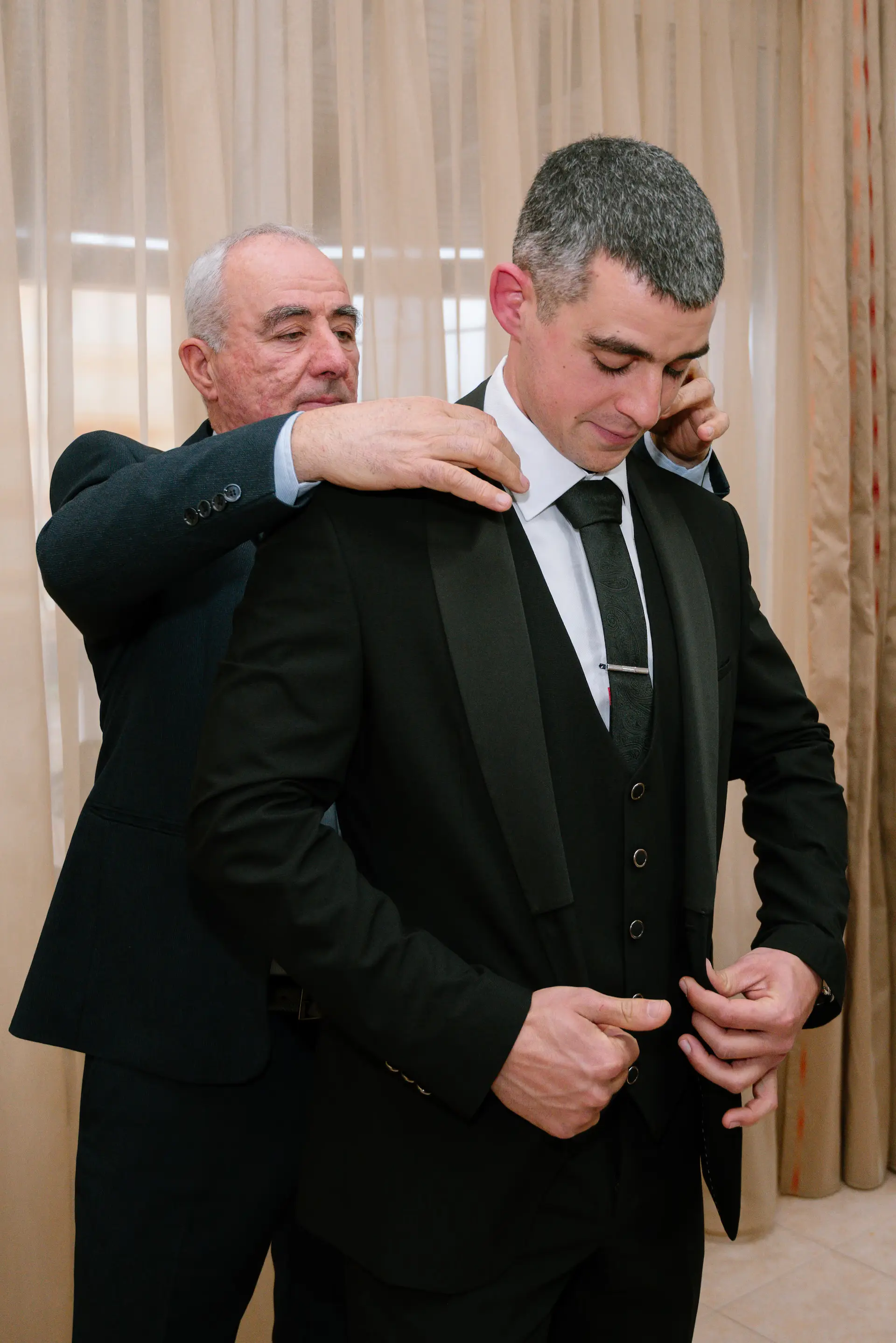father dresses the groom