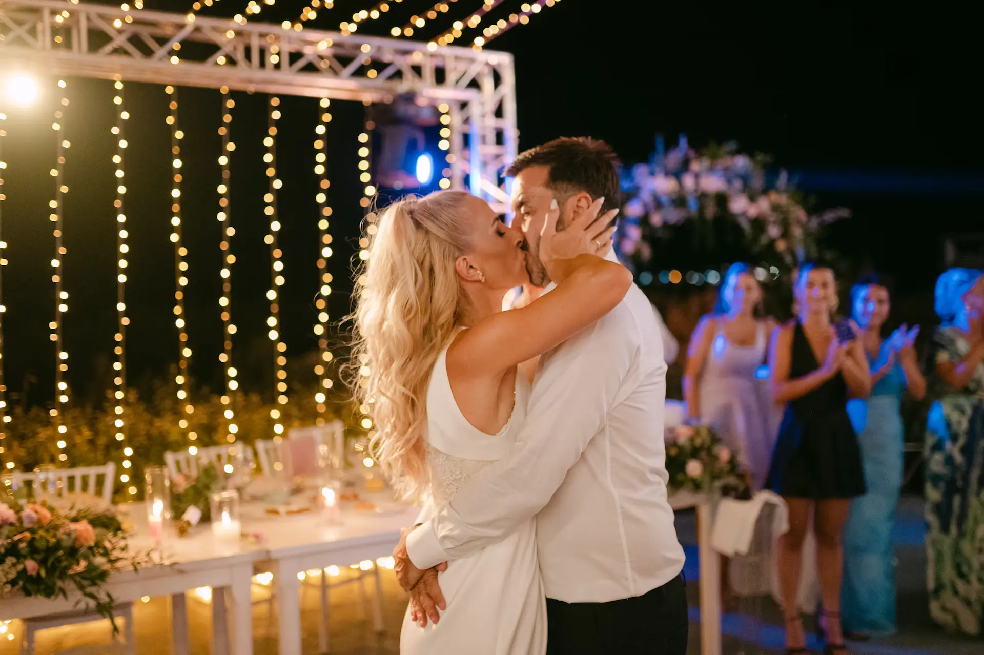 passionate kiss from the couple and their friends cheering in the background
