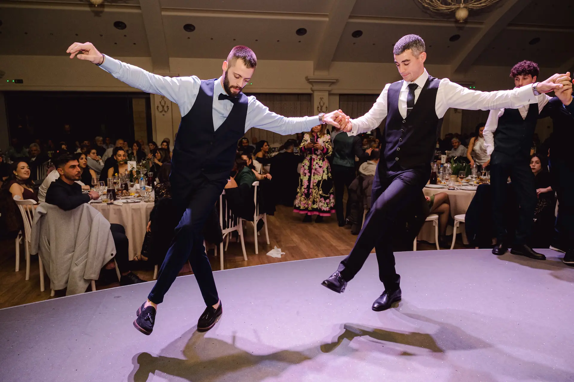 Groom and his best man performing a traditional Cretan dance during the wedding reception.
